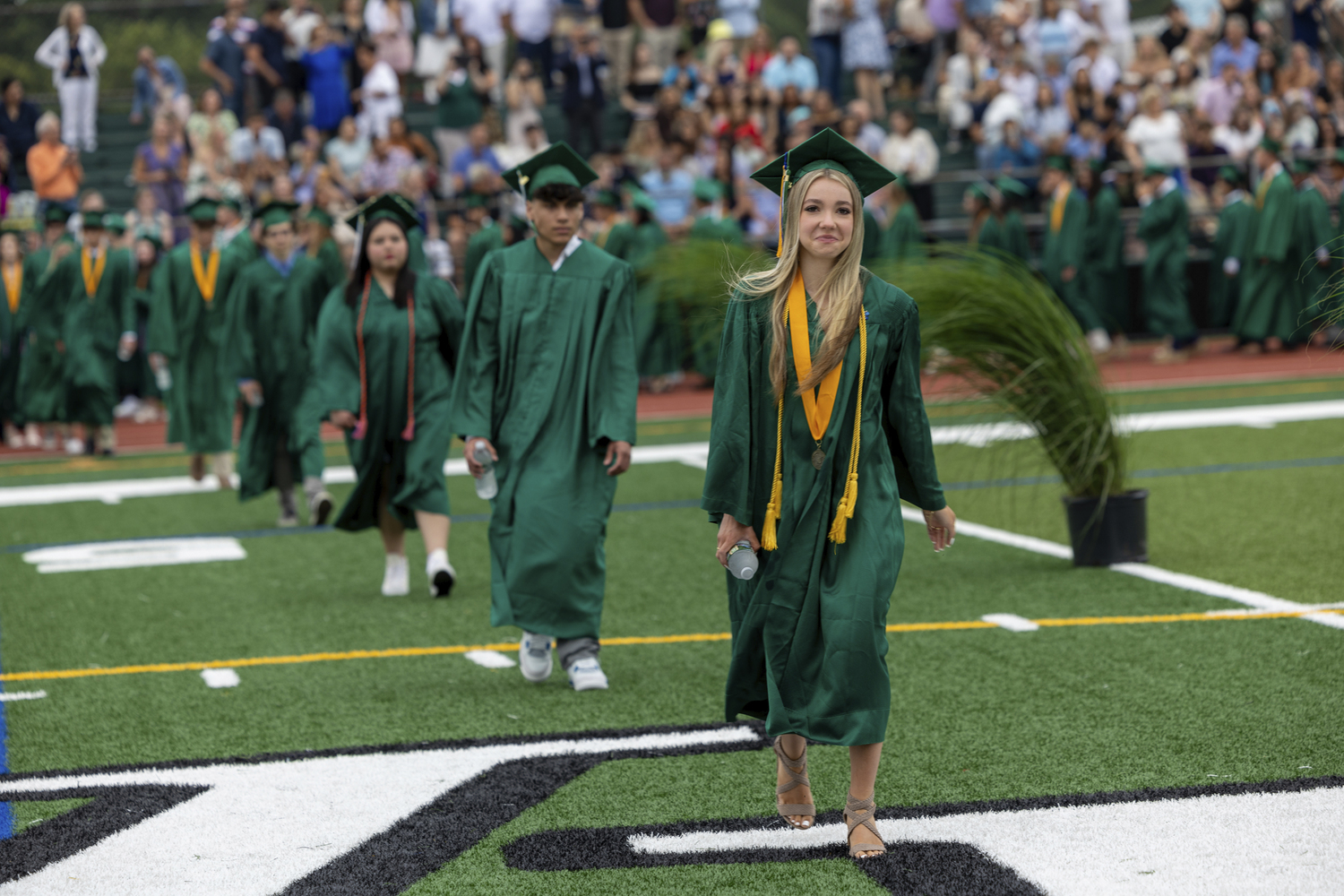 Graduates make their way on to the field at Westhampton Beach High School commencement on June 26.    RON ESPOSITO