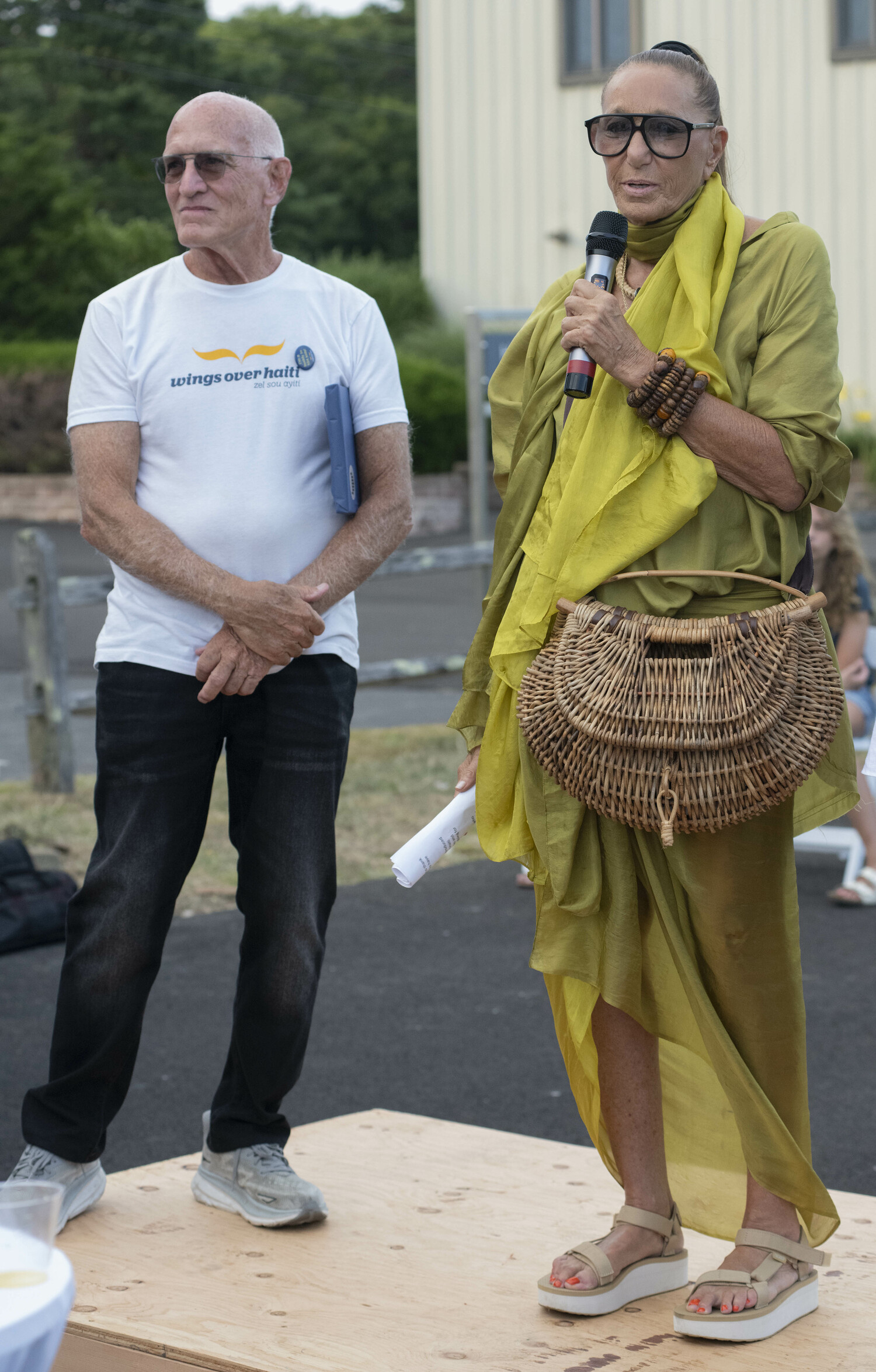 The Wings Over Haiti Benefit was held at The East Hampton Airport honoring Donna Karan for her commitment of helping Haiti. There was a silent art auction to help raise money for the charity that Jonathan Nash Glynn founded following the devastating earthquake in 2010. Donna Karan addresses the crowd while Jonathan Nash Glynn stands beside her.  DOUG KUNTZ