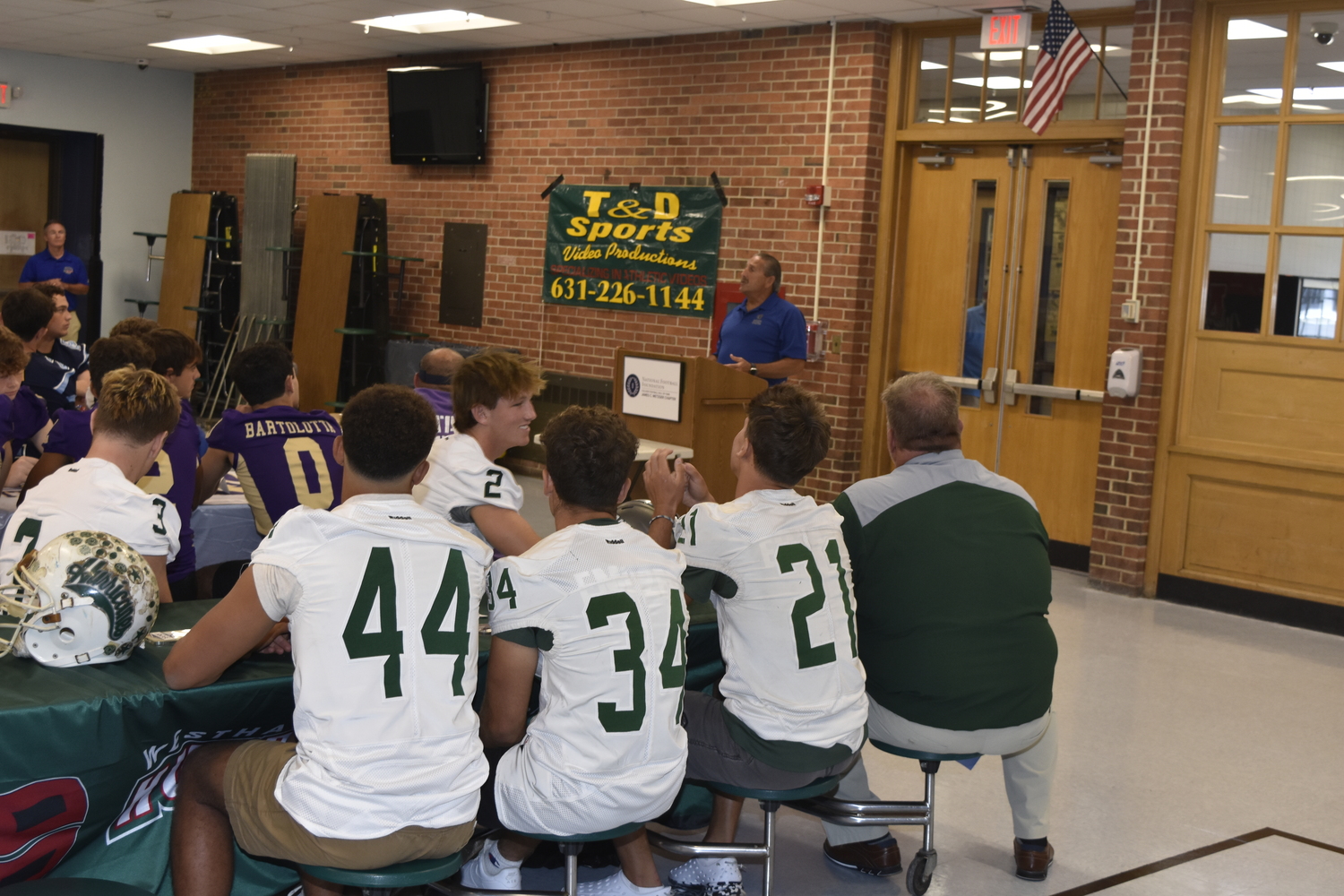 The Hurricanes look on as Peter Blieberg of the Suffolk County Football Coaches Association and Football Foundation speaks.  DREW BUDD