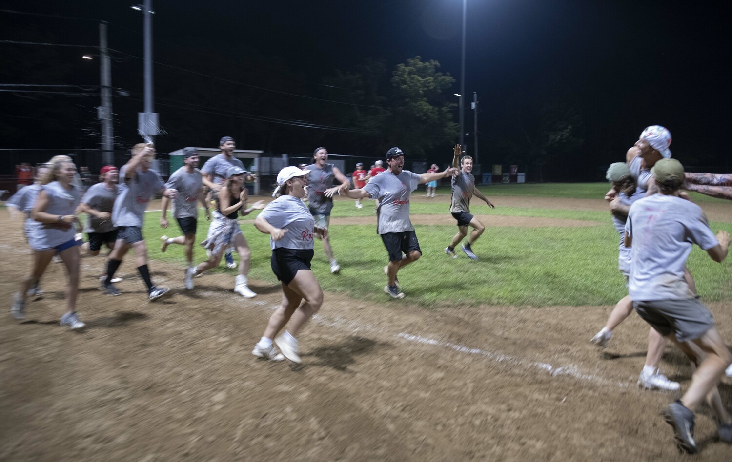 Members of the Raptors rush the field after the winning run is scored.  DOUG KUNTZ