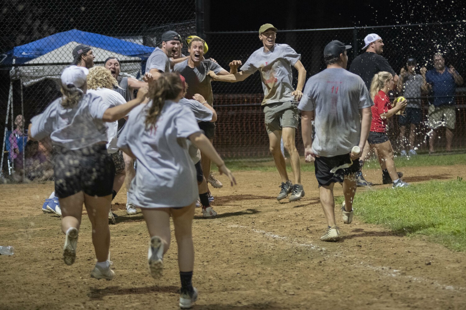 Members of the Raptors rush the field after the winning run is scored.  DOUG KUNTZ