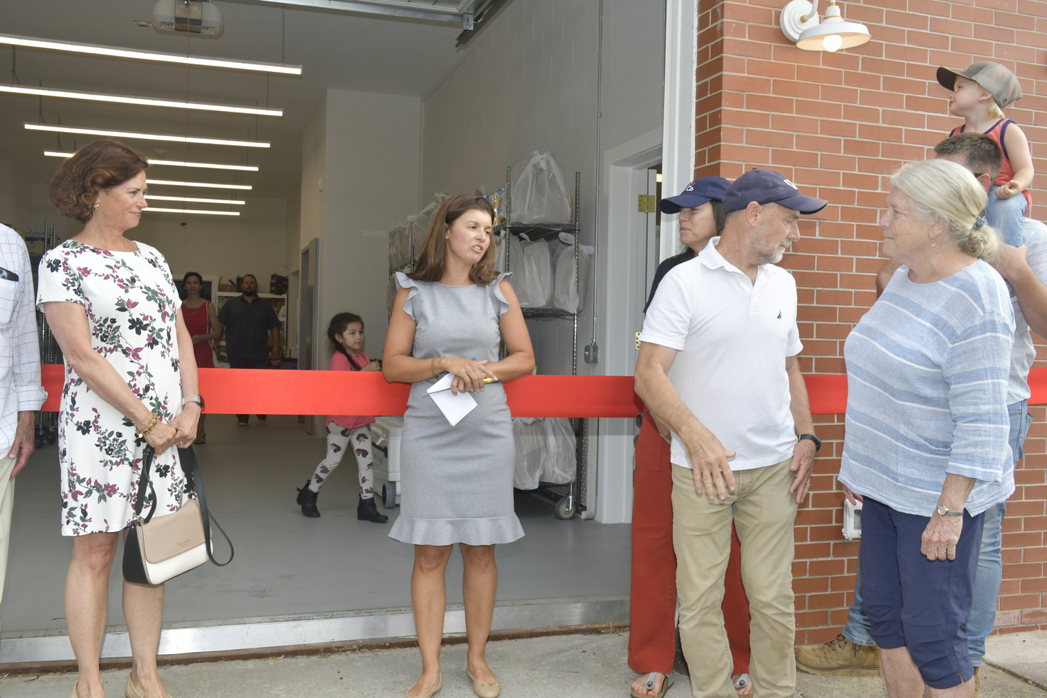 Heart of the Hamptons Executive Director Molly Bishop welcomes the crowd to the ribbon cutting at the new headquarter on Meeting House Lane on July 31.   DANA SHAW