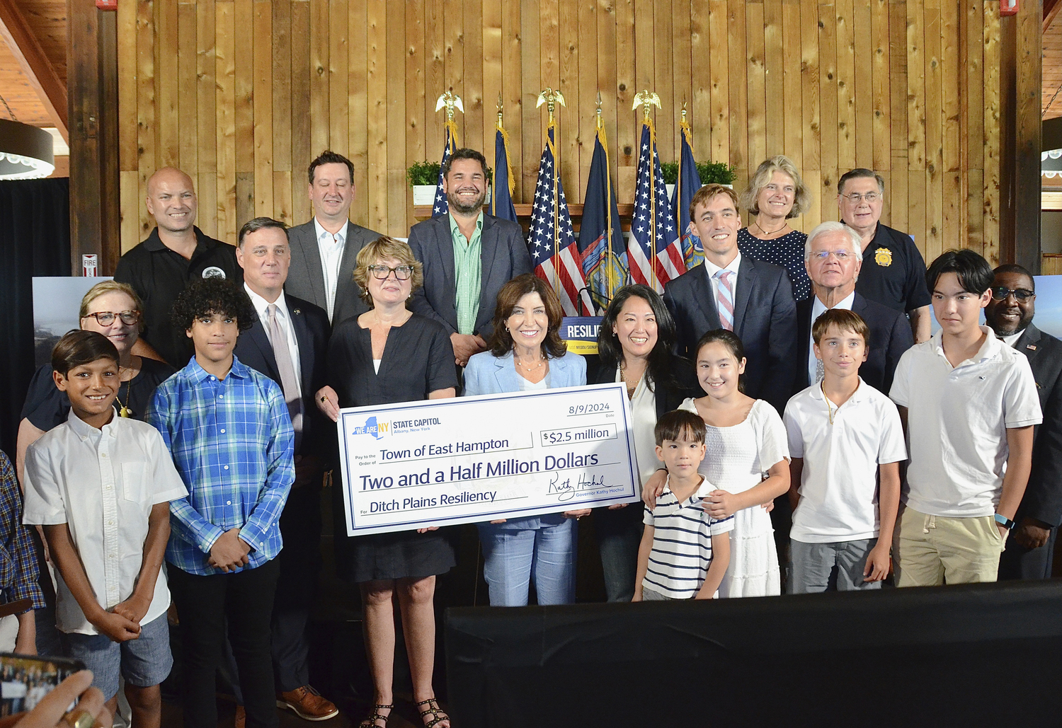 East Hampton Town Supervisor Kathee Burke-Gonzalez, Gov. Kathy Hochul, Kay Tyler of Concerned Citizens of Montauk and Leo Daunt of the Montauk Chamber of Commerce hold the ceremonial $2.5 check to be allocated to dune restoration at Ditch Plains in Montauk.        KYRIL BROMLEY