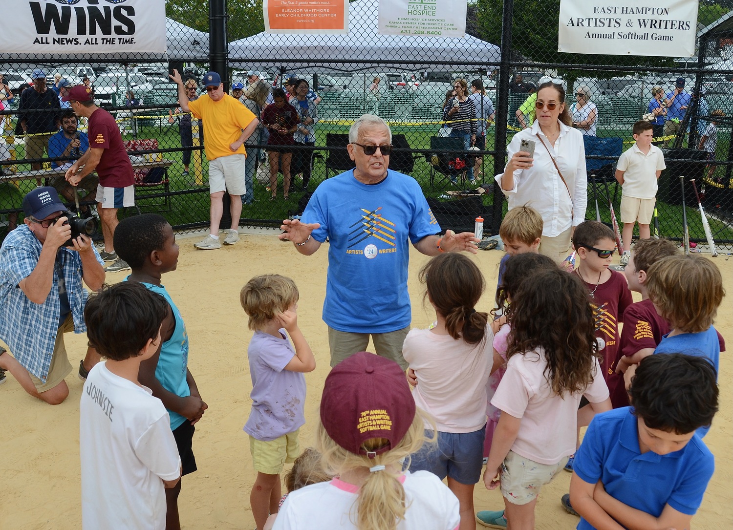 Mike Lupica gathers kids for the spin-the-bat run around the bases in the middle of Saturday's game.   KYRIL BROMLEY