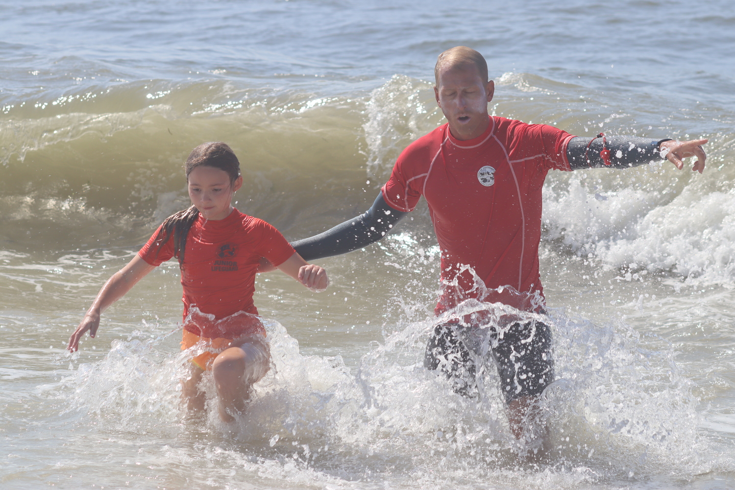 Southampton Town Lifeguard Dan Garvey helps a swimmer out of the water. CAILIN RILEY