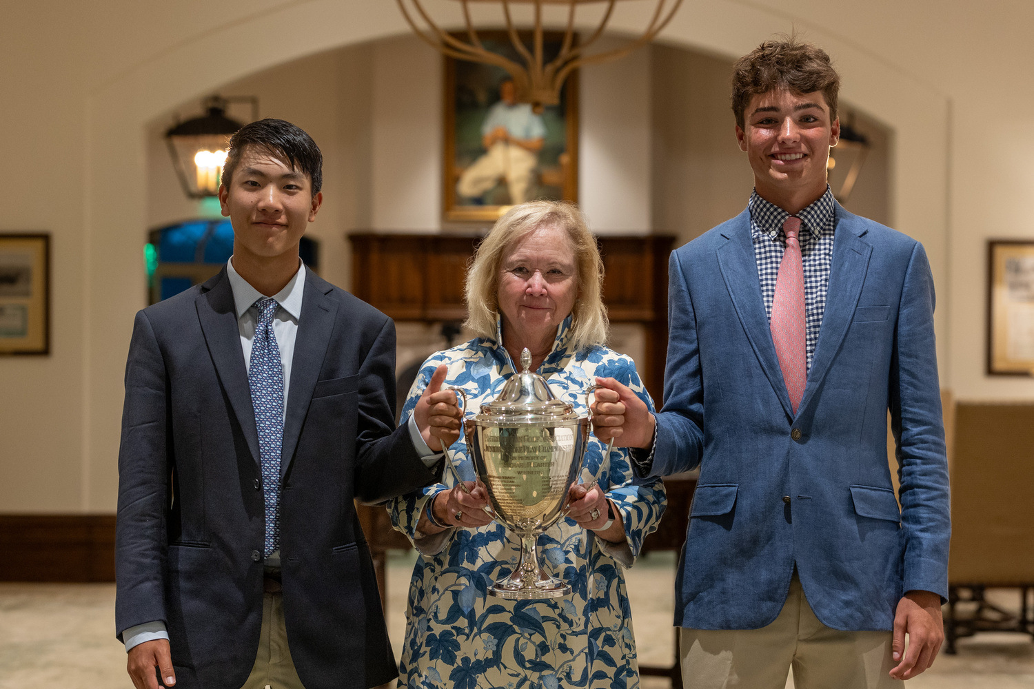 Jack Chung, left, Mary Lou Carter, mother of the tournament’s namesake, and Owen Jessop holding up the Carter Cup trophy.  METROPOLITAN GOLF ASSOCIATION