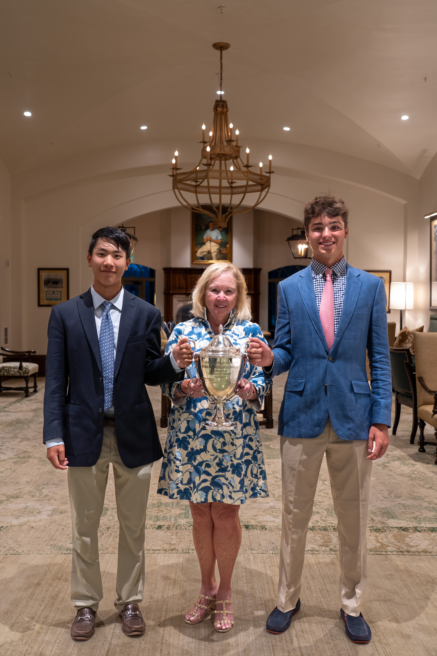 Jack Chung, left, Mary Lou Carter, mother of the tournament’s namesake, and Owen Jessop holding up the Carter Cup trophy.  METROPOLITAN GOLF ASSOCIATION