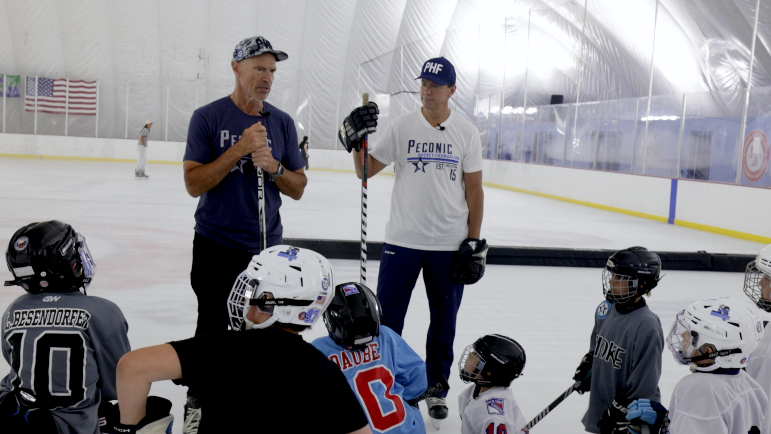 Mark Messier, along with Troy Albert, speaks to players of Peconic Hockey.   COURTESY JIM TAMBURINO