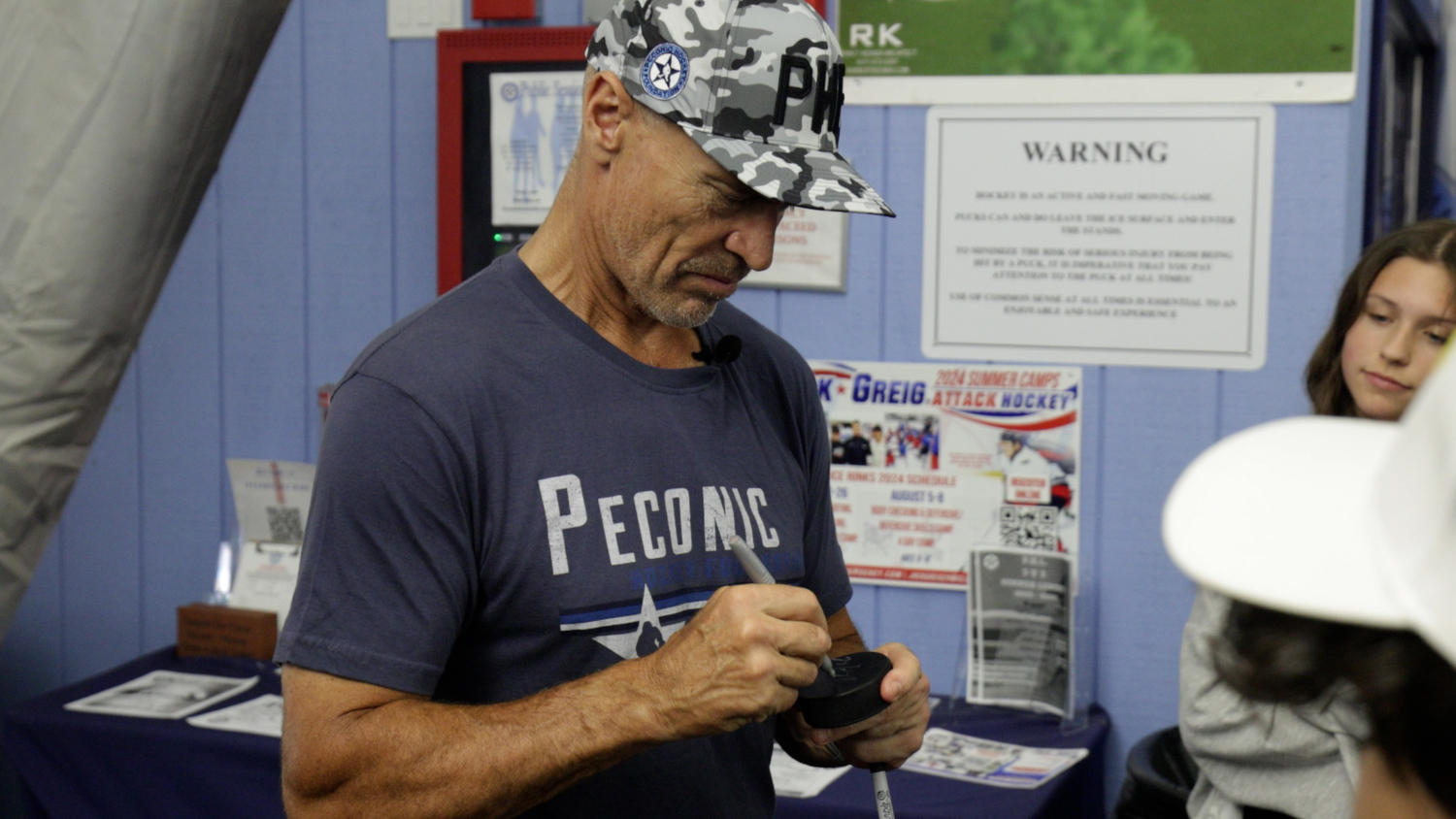 Mark Messier signs a puck.   COURTESY JIM TAMBURINO