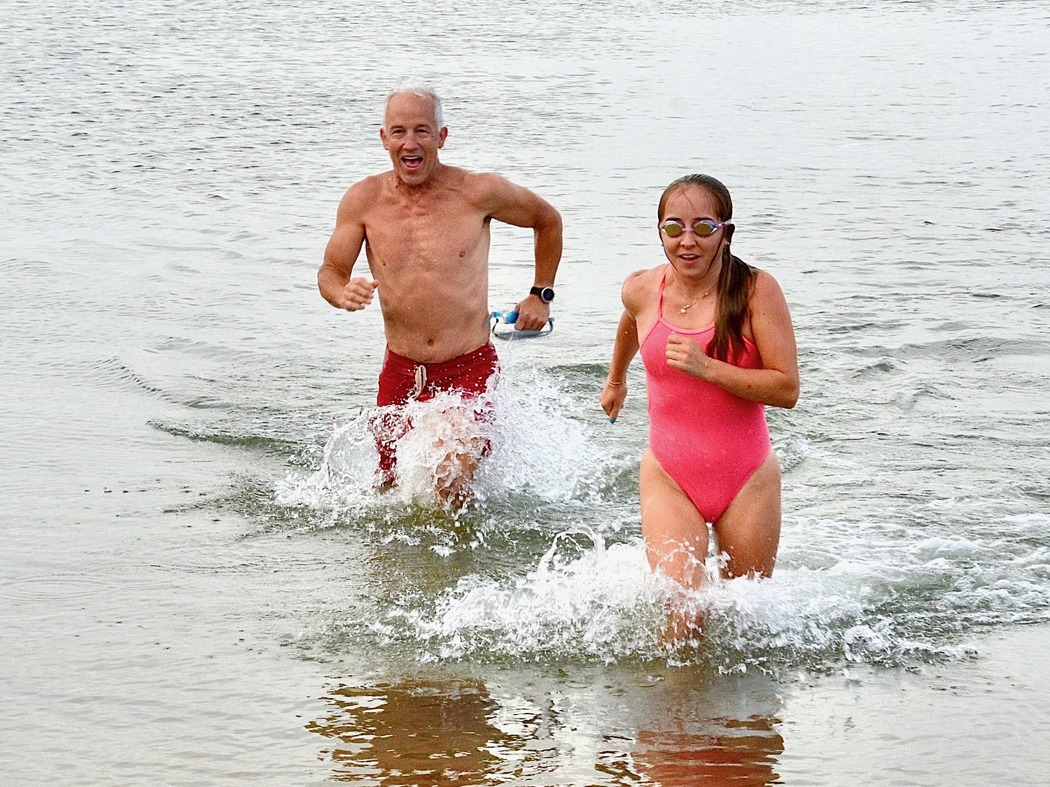 East Hampton resident Mike Bahel and his daughter, Alyssa, exit the water at Albert's Landing during triathlon training in Amagansett. KYRIL BROMLEY