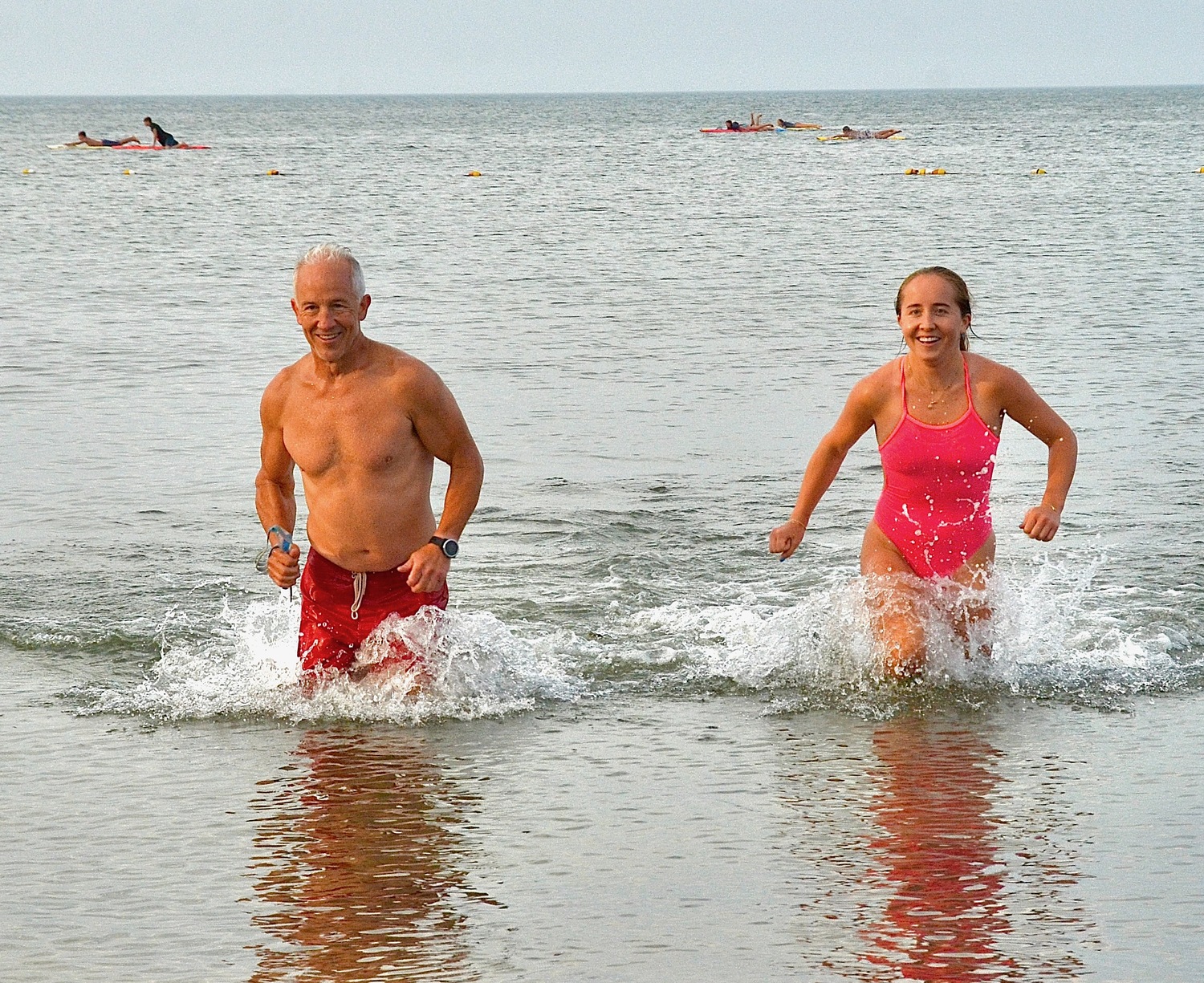 East Hampton resident Mike Bahel and his daughter, Alyssa, exit the water at Albert's Landing during triathlon training in Amagansett. KYRIL BROMLEY