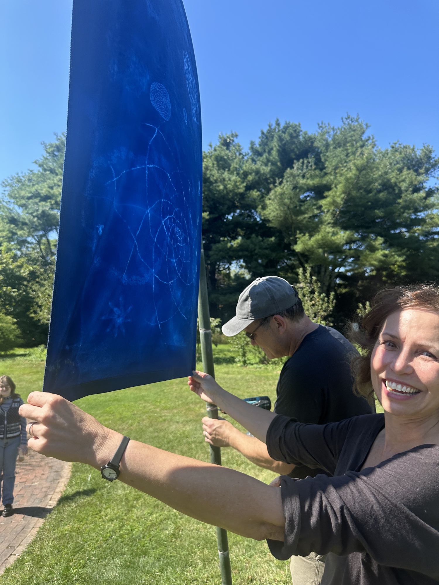 Artist Andrea Cote and her husband, Pierre, hanging her cyanotype banners at Bridge Gardens on September 9. ANNETTE HINKLE