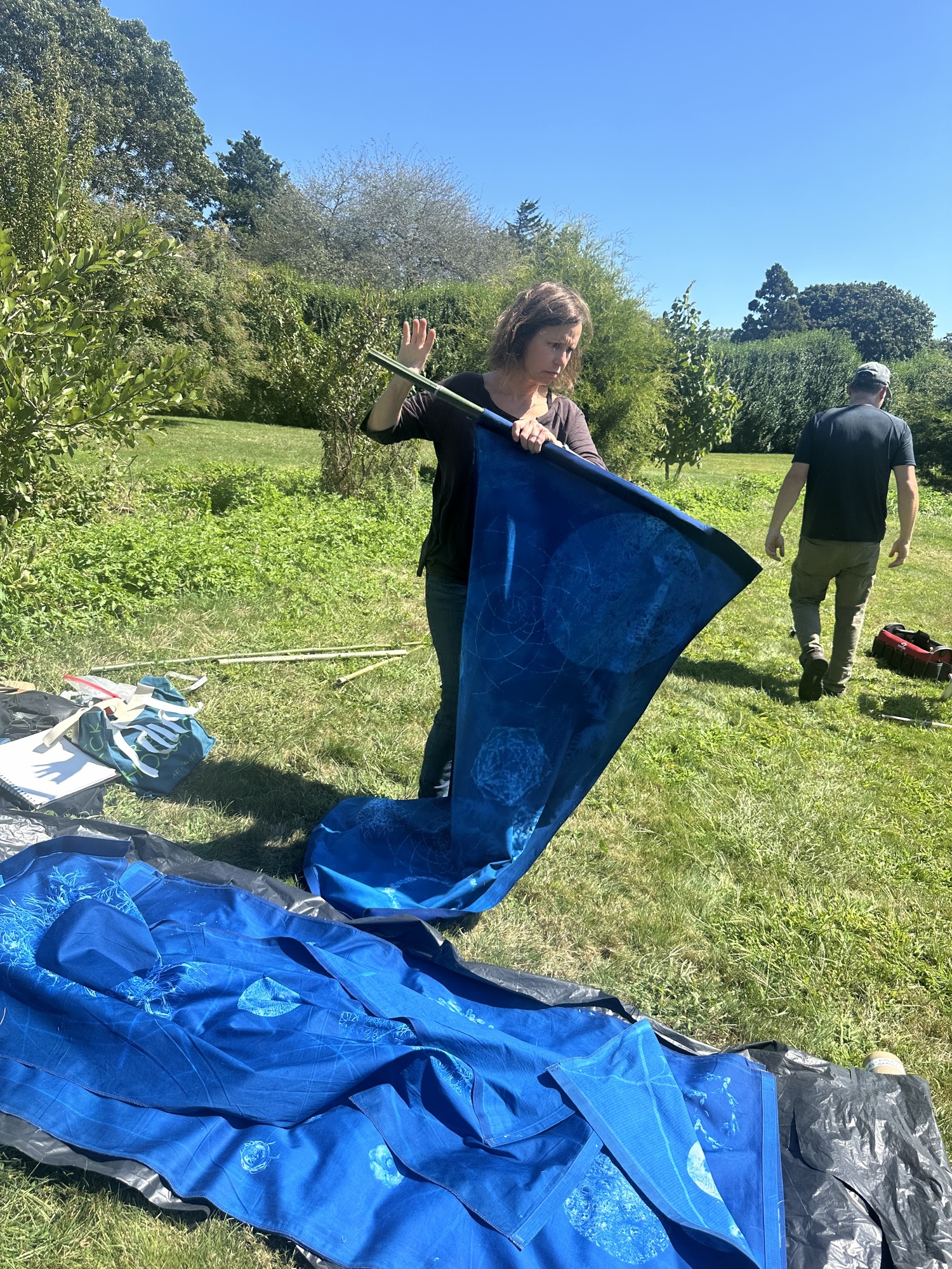 Artist Andrea Cote and her husband, Pierre, hanging her cyanotype banners at Bridge Gardens on September 9. ANNETTE HINKLE