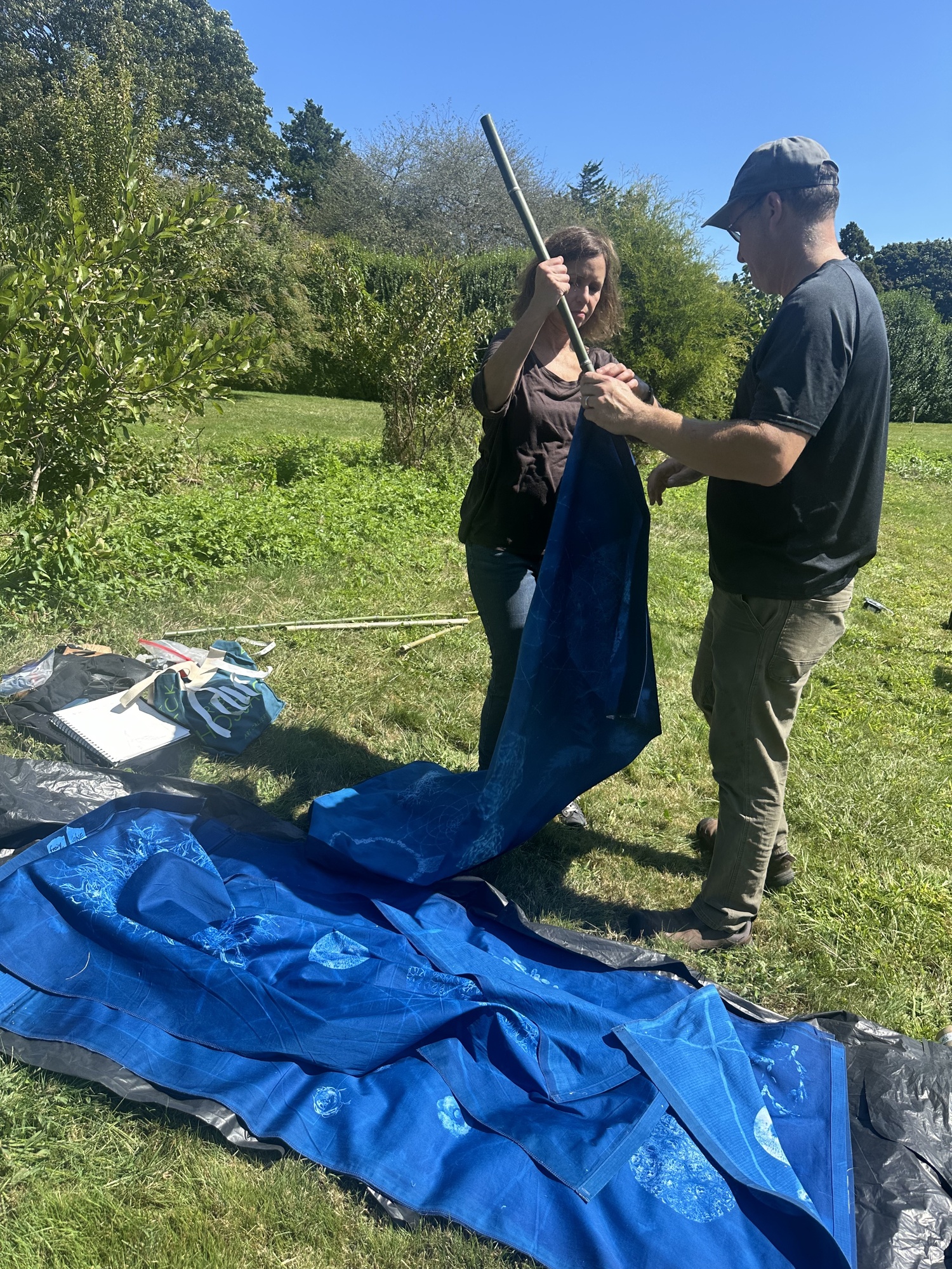 Artist Andrea Cote and her husband, Pierre, hanging her cyanotype banners at Bridge Gardens on September 9. ANNETTE HINKLE