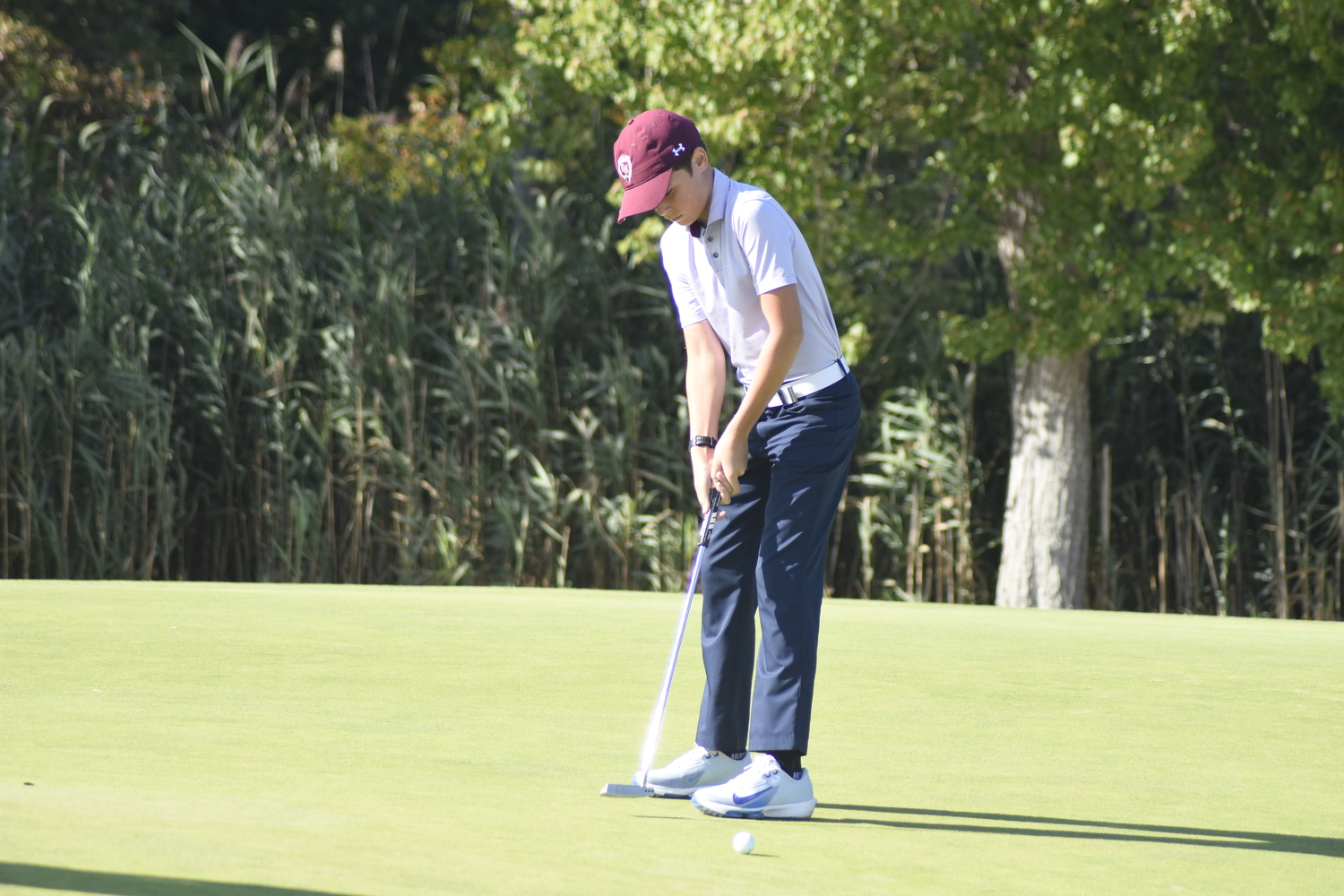 East Hampton eighth-grader Cole DeLand tries to make a putt on one in last week's match.  DREW BUDD