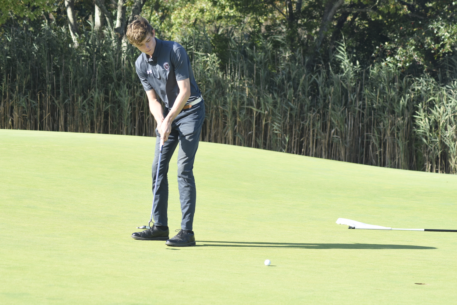 East Hampton junior Colin Kelly putts on one at Westhampton Country Club.   DREW BUDD