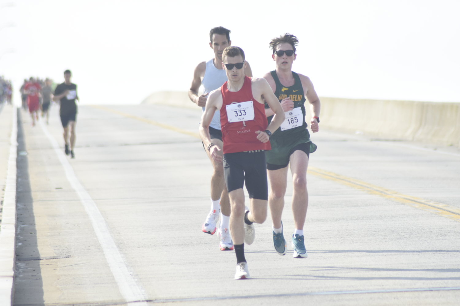 Nick Berglin leads a group of runners that also includes Mathew Sabolenko and Jack Stevens, over Ponquogue Bridge in Hampton Bays for the Over the Bridge races on Saturday morning.   DREW BUDD