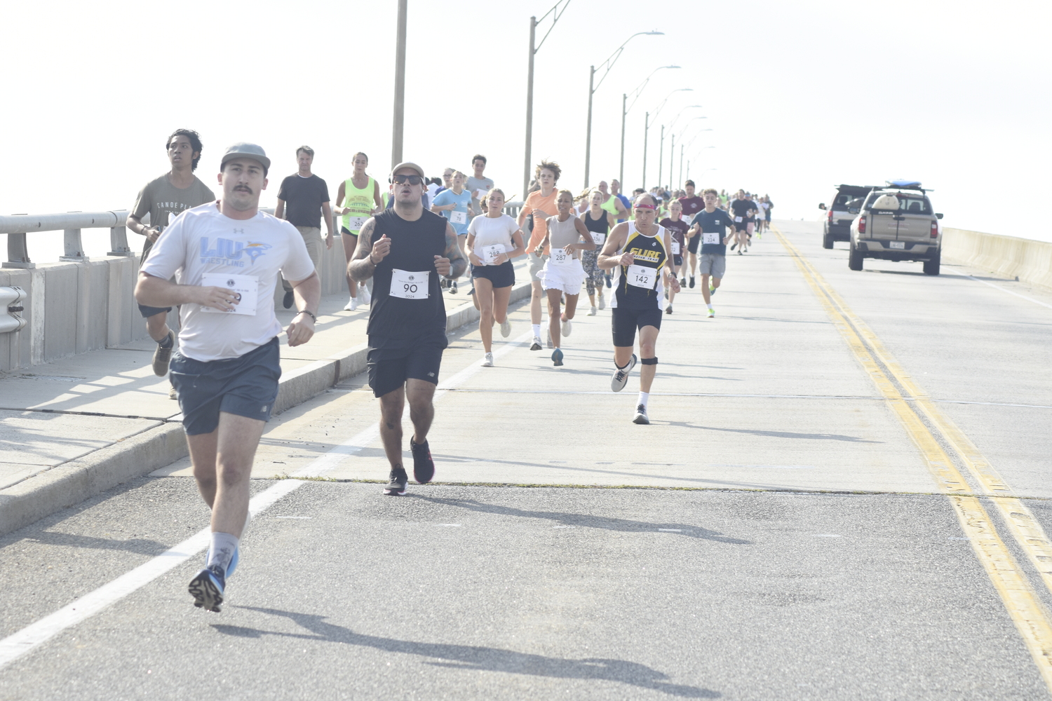 Runners head over Ponquogue Bridge in Hampton Bays on Saturday morning.   DREW BUDD