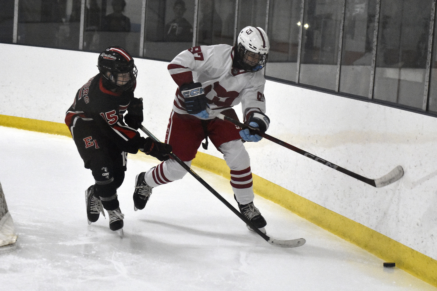 Aidan D'Angelo and an East Islip player go for a loose puck behind the Whalers' goal.   DREW BUDD