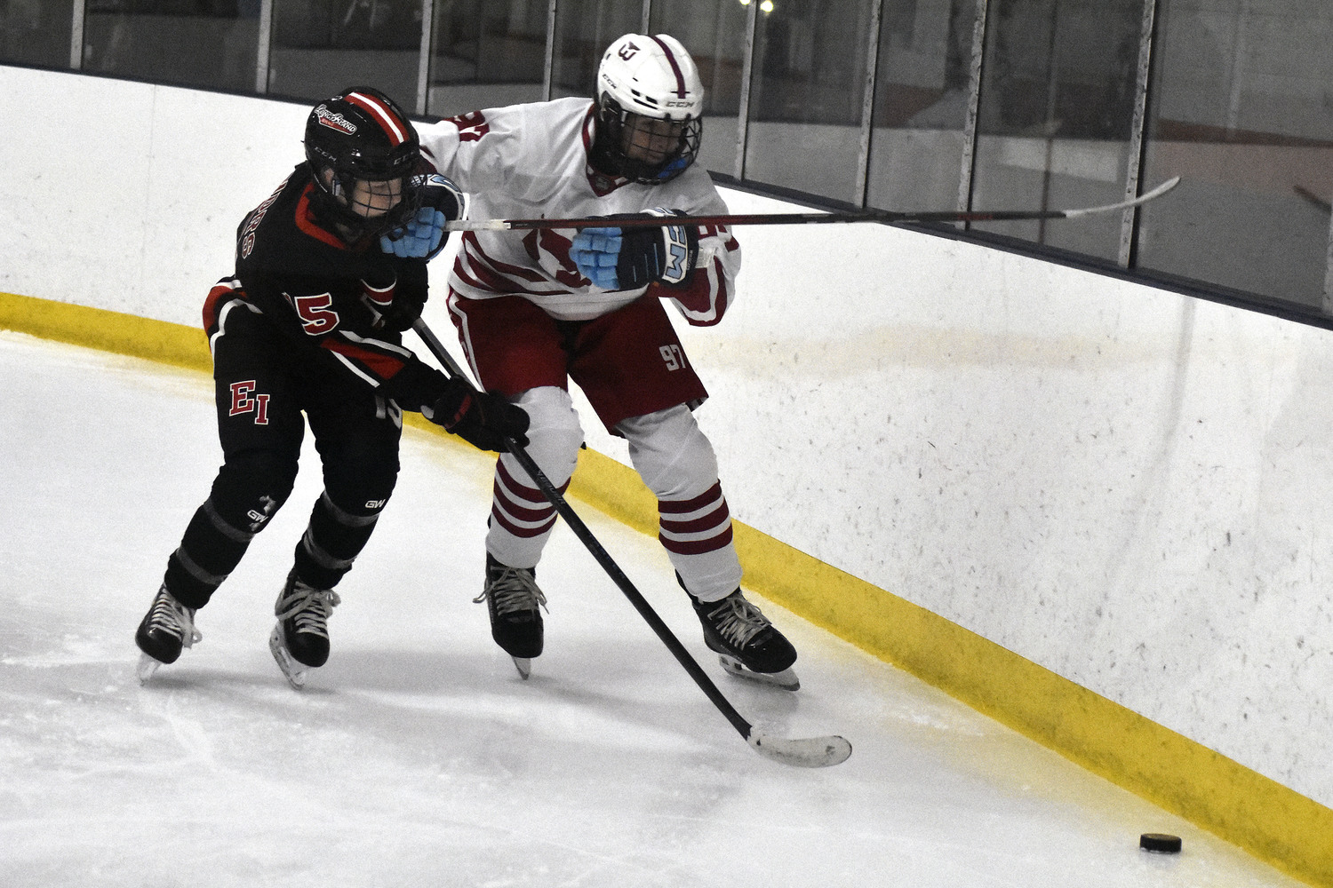 Aidan D'Angelo and an East Islip player go for a loose puck behind the Whalers' goal.   DREW BUDD