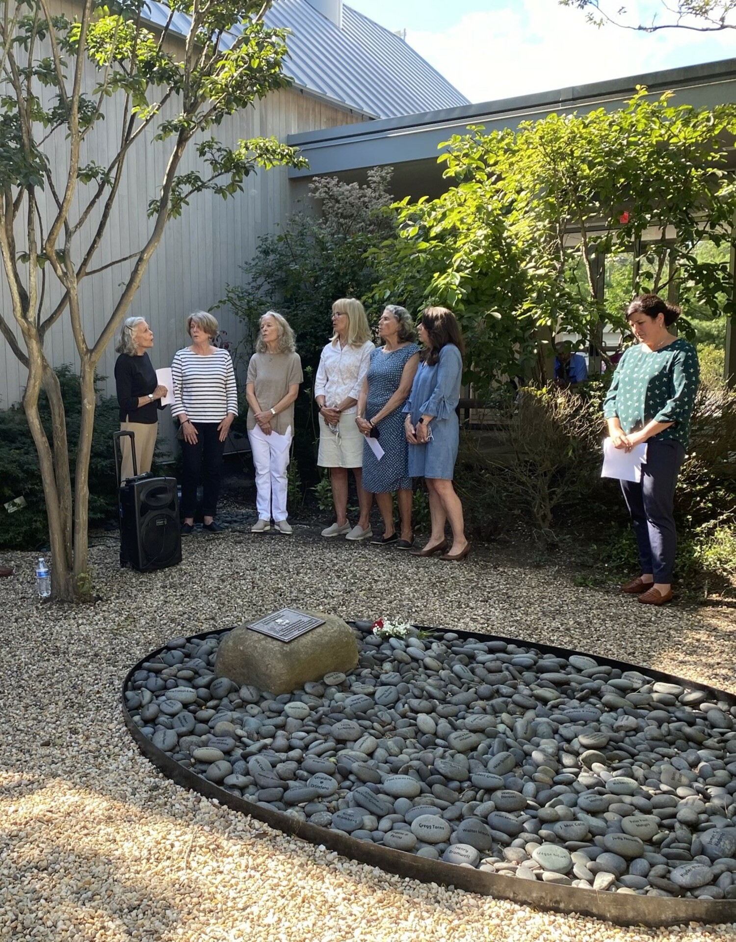 Threshold Singers, from left, Carol Johns, Claire Watson, Sarah Jaffe Turnbull, Alice Froehlich, Colleen Gilmartin, Michelle Mulligan and Mary Crosby, sing in the Memorial Rock Garden at East End Hospice. COURTESY EAST END HOSPICE