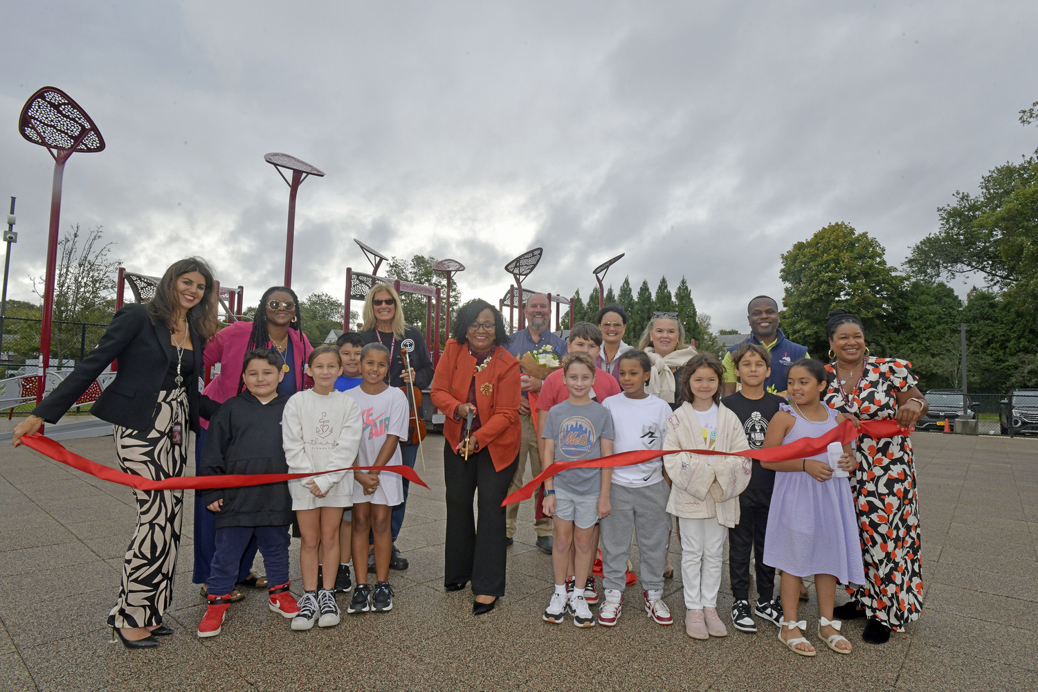 Superintendent of the Southampton Union Free School District Dr. Fatima Morrel cuts the ribbon on the new new playground at Southampton Elementary School on September 20. The new equipment features bridges, climbing walls, monkey bars, multiple slides and musical instruments, including drums, chimes and xylophones. A new, safe playground surface was also installed. The $342,000 playground project was approved by voters in May 2024 through a Capital Reserve Fund vote. The playground replaces a 20-year-old play structure.   DANA SHAW