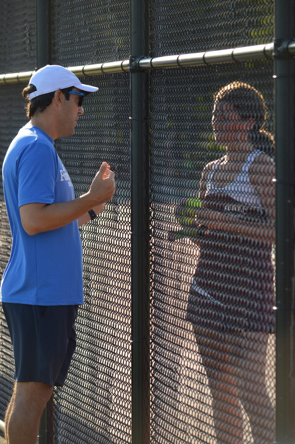 East Hampton tennis coach Pablo Montesi talking to Ella Menu during her first singles match against Sachem on Tuesday. GAVIN MENU