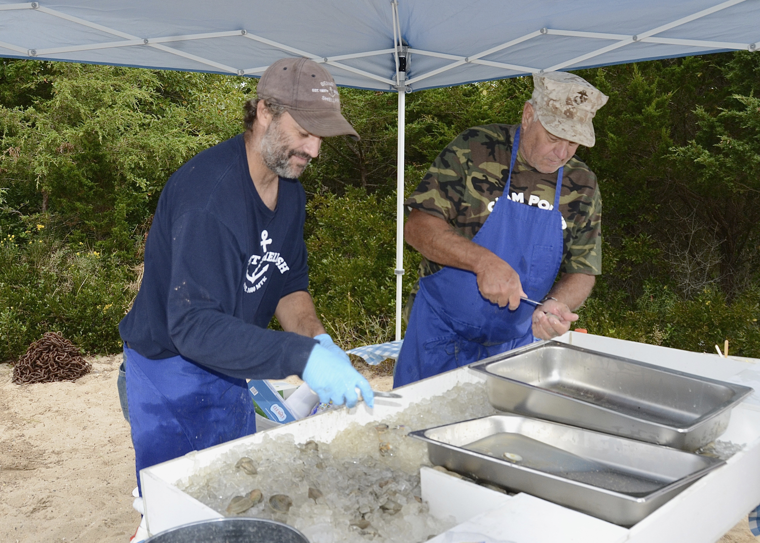 Clint Bennett Junior and Senior shuck clams.  KYRIL BROMLEY