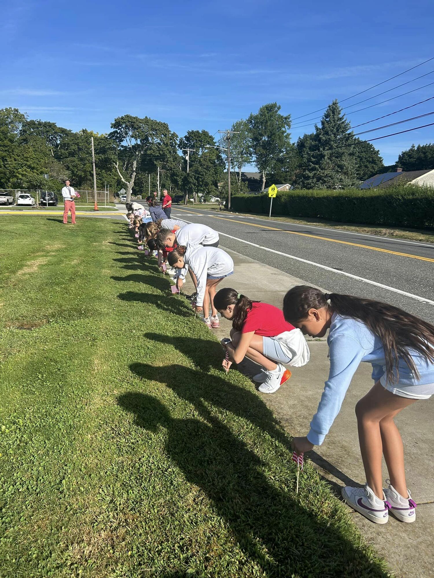 Dressed in patriotic colors, East Quogue School sixth grade students paid tribute to
those who lost their lives and to the heroes of September 11 by placing flags on the front lawn of the school. During the morning announcements, there was also a moment of silence and a reminder of the historical importance of the day. COURTESY EAST QUOGUE SCHOOL