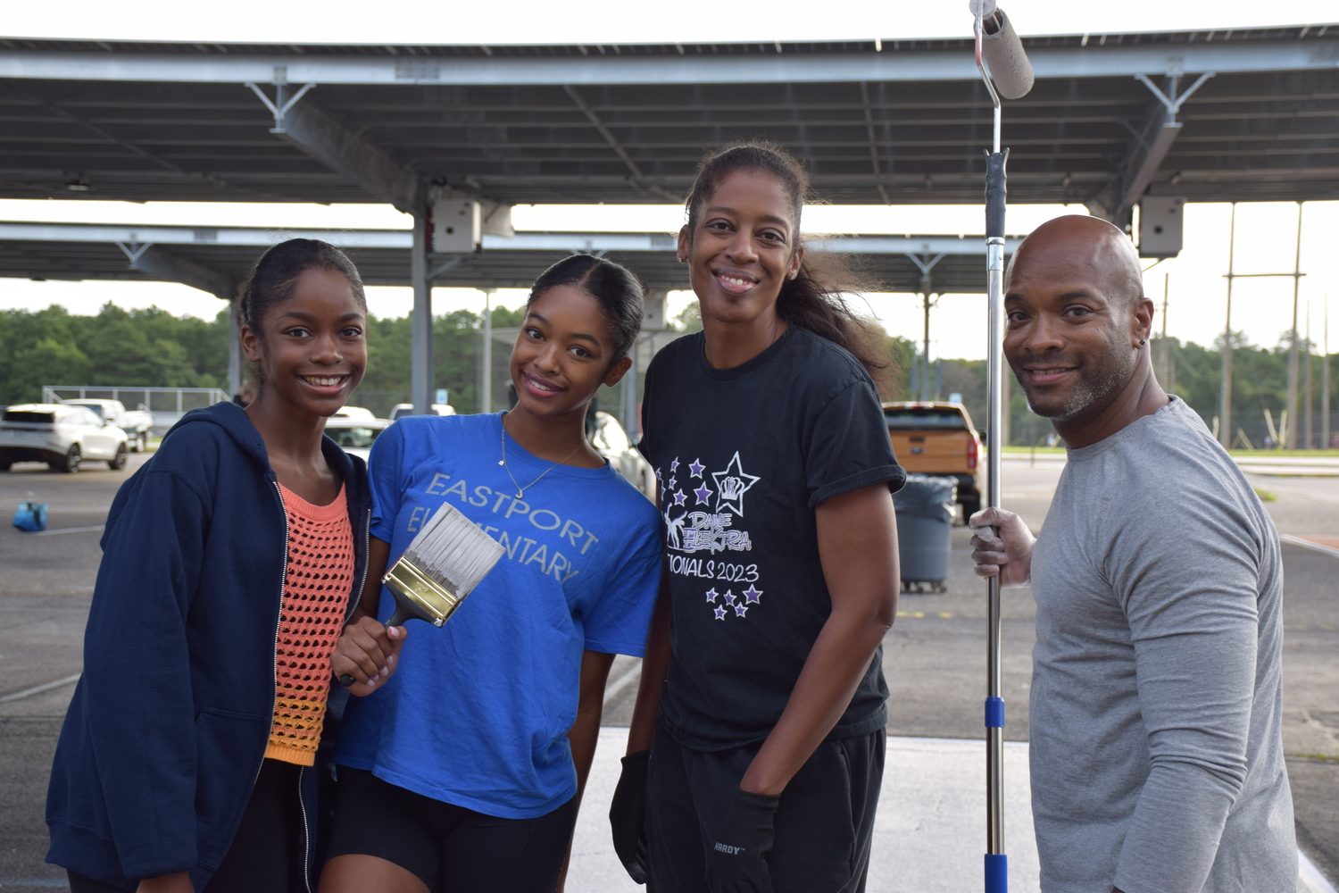 Equipped with rollers, paint brushes, stencils and paint cans, Eastport-South Manor Jr.-Sr. High School seniors arrived in the early morning hours to start painting their assigned parking spaces during the school’s annual Paint Day, held on August 29. Some of the students were accompanied by peers, while others made the activity a family affair.  Jasmine Taylor with her sister Ashlynn Taylor, her mother Jamila Taylor and her father Sam Taylor.  COURTESY EASTPORT-SOUTH MANOR SCHOOL DISTRICT