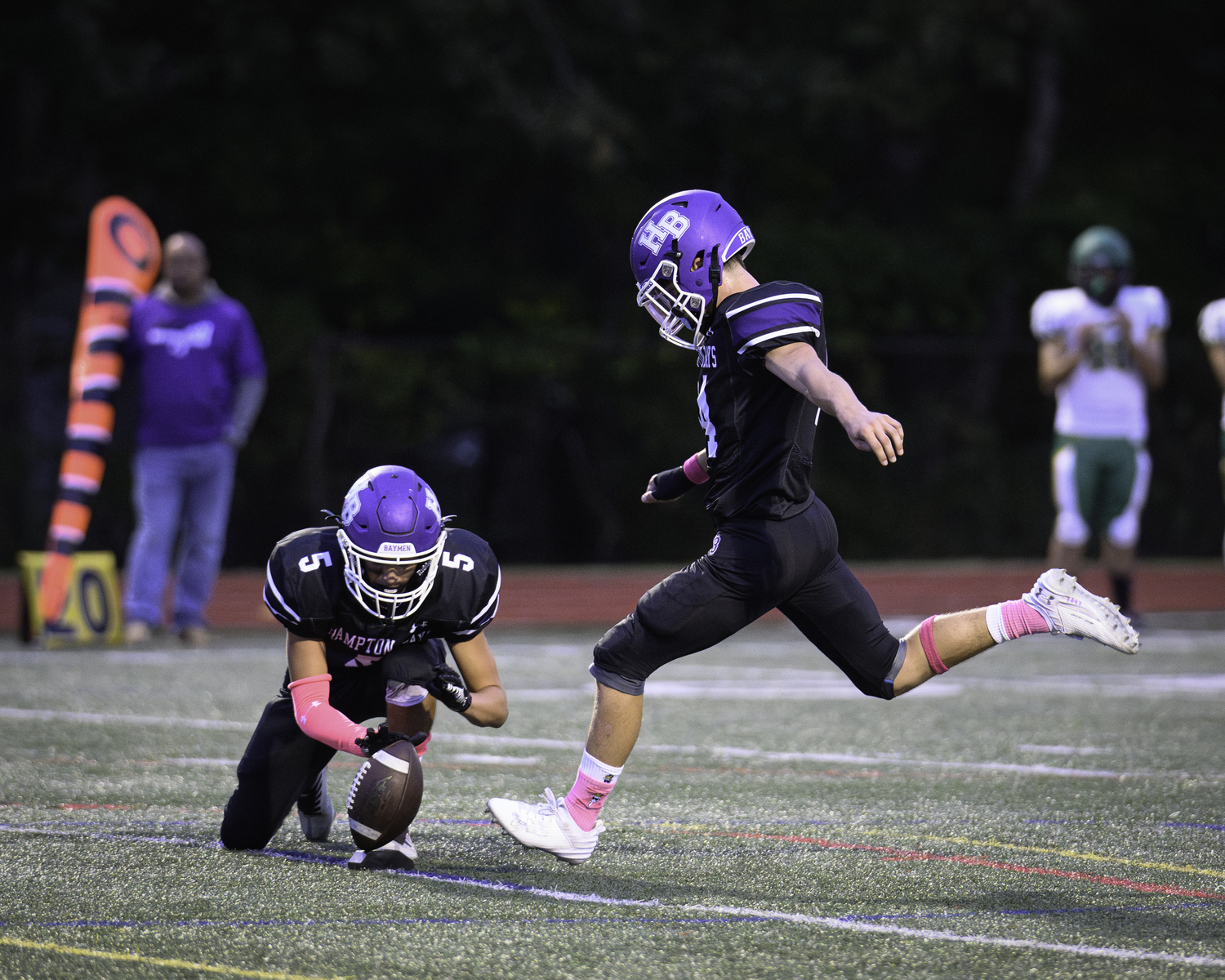 Hampton Bays senior Hunter Halsey holds the ball for sophomore Michael Single kicking an extra point after a touchdown.   MARIANNE BARNETT