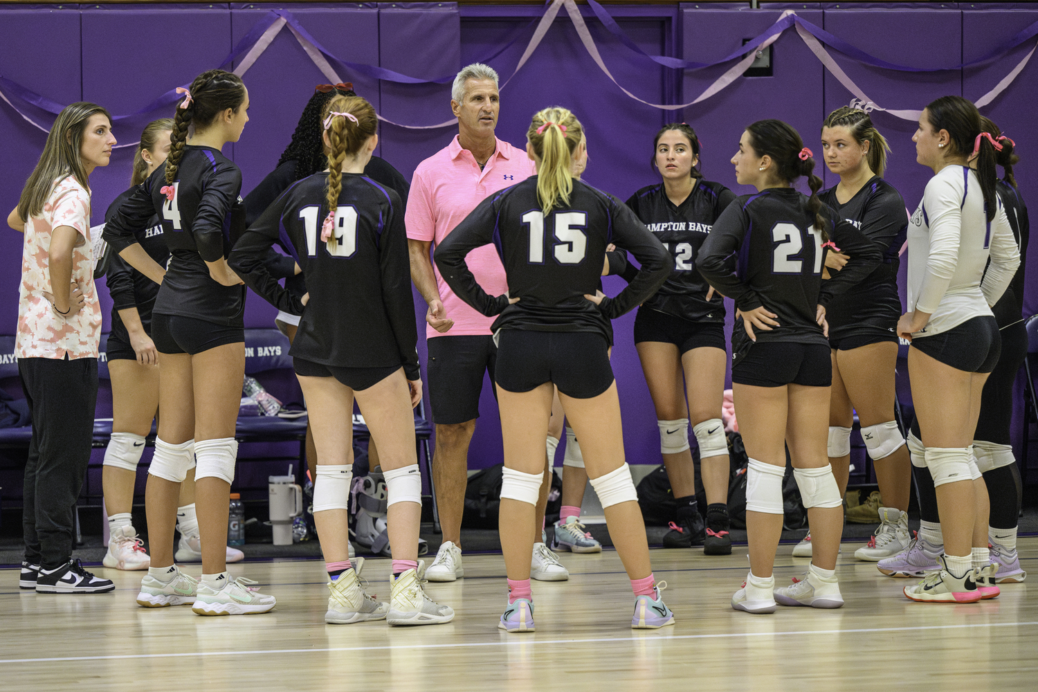 Hampton Bays' girls volleyball team members meet with head coach Andy Fotopoulos during a timeout. MARIANNE BARNETT