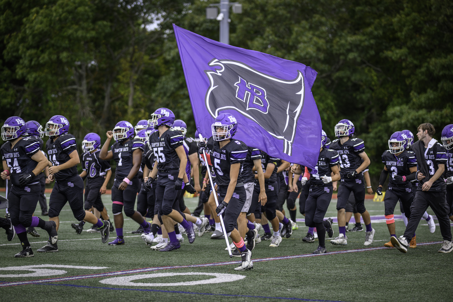 Hunter Halsey carried the Baymen flag onto the field just prior to the start of Friday night's homecoming game.   MARIANNE BARNETT