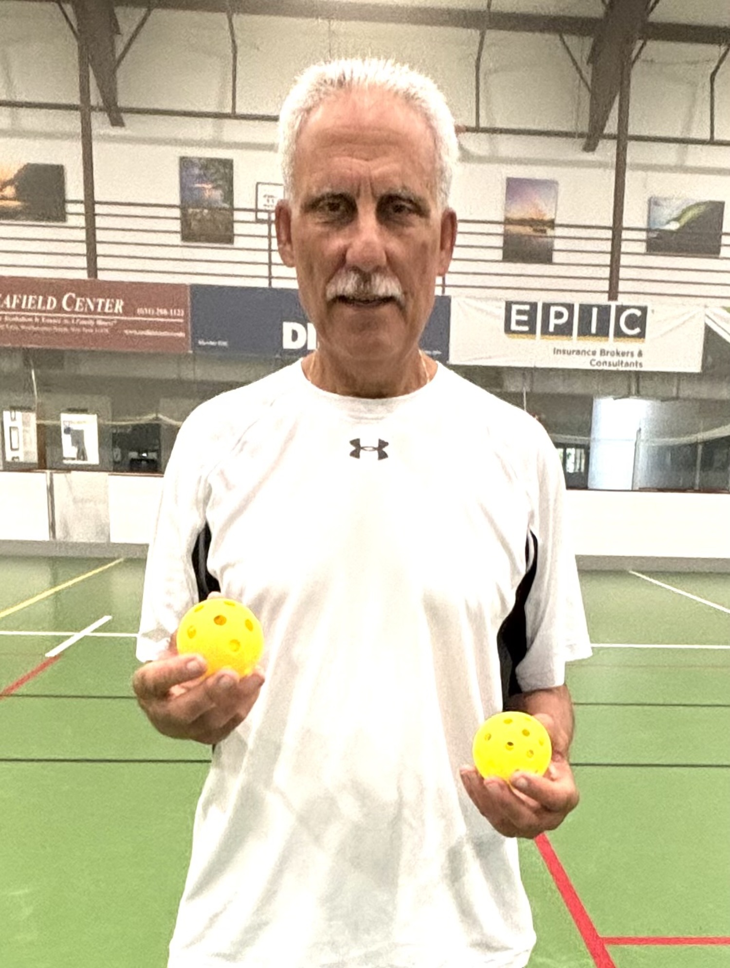 Vinny Mangano holds a pair of pickleballs.