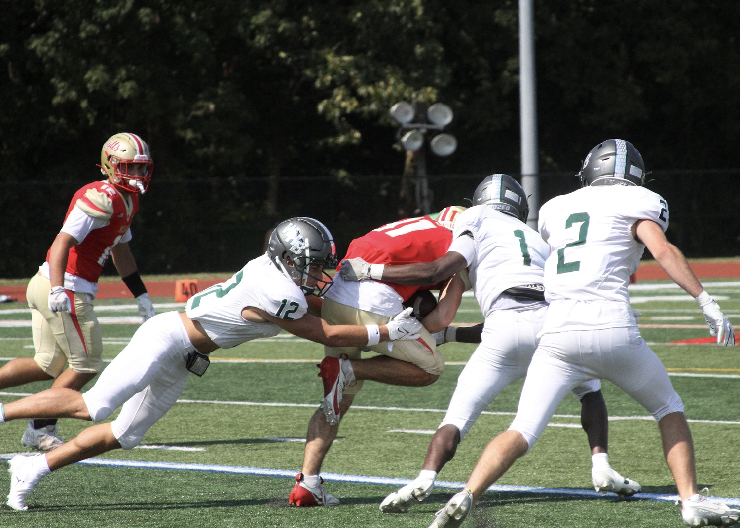 Senior running back Brody Schaffer, junior cornerback Antonio Washington and senior strong safety Finn Drake make a tackle. DESIRÉE KEEGAN