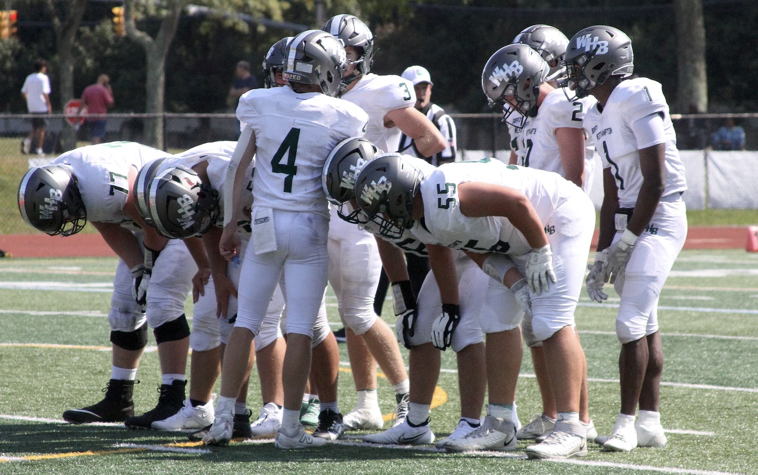 Members of Westhampton Beach's football team huddle around sophomore quarterback Jake Calloway before a play. DESIRÉE KEEGAN