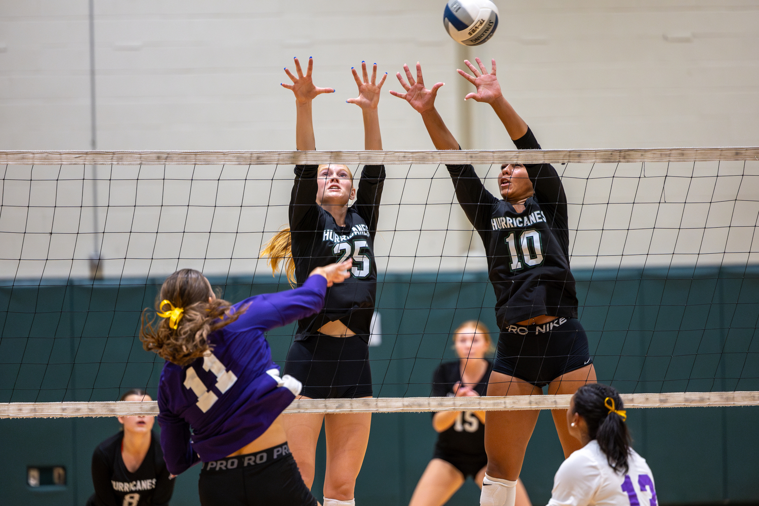 Junior right side Mia Hill and junior outside hitter Jasmine Taylor leap for a block in a game against Islip. RON ESPOSITO