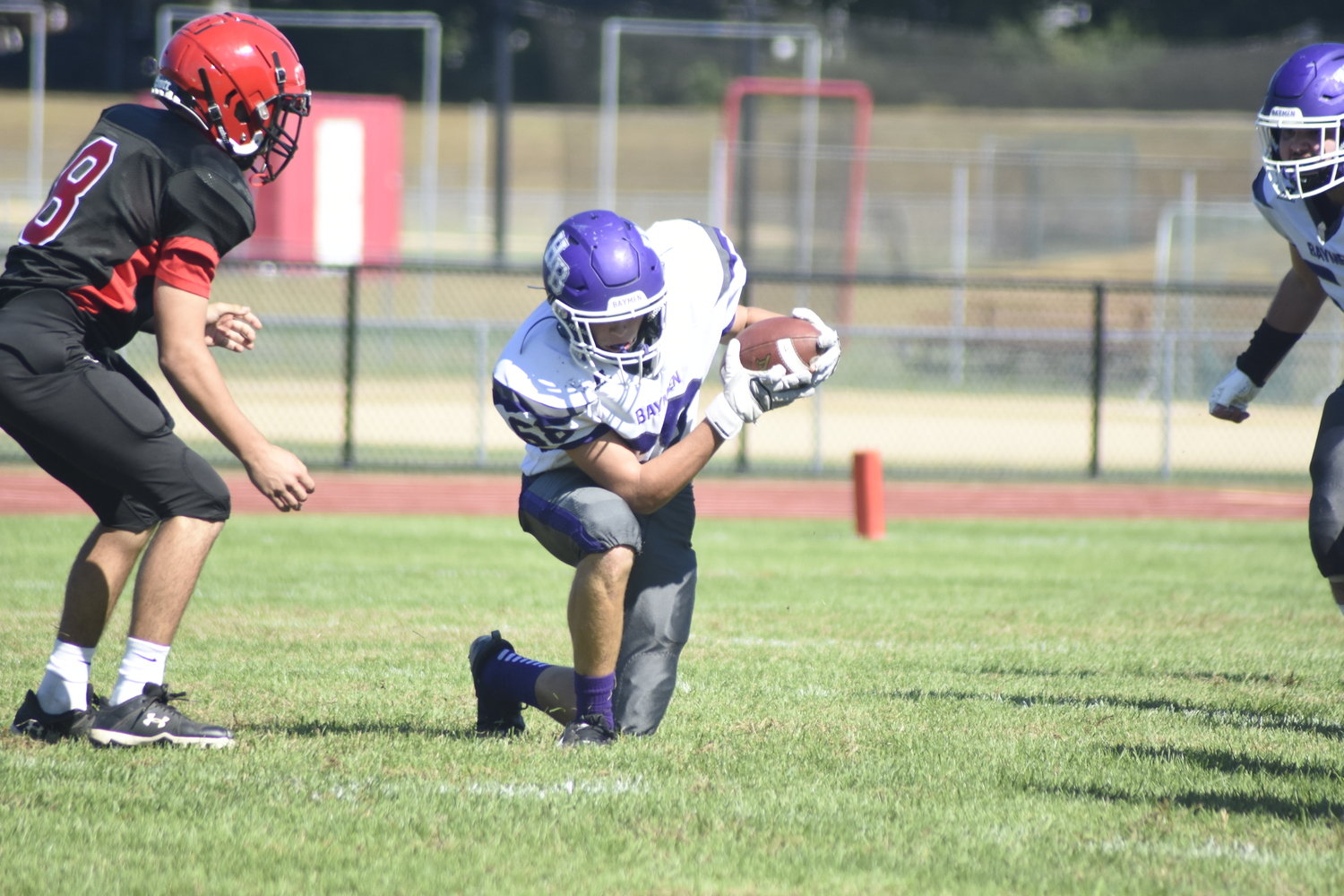 Junior Peter Scelfo scoops up a botched snap that results in a turnover for the Baymen.   DREW BUDD