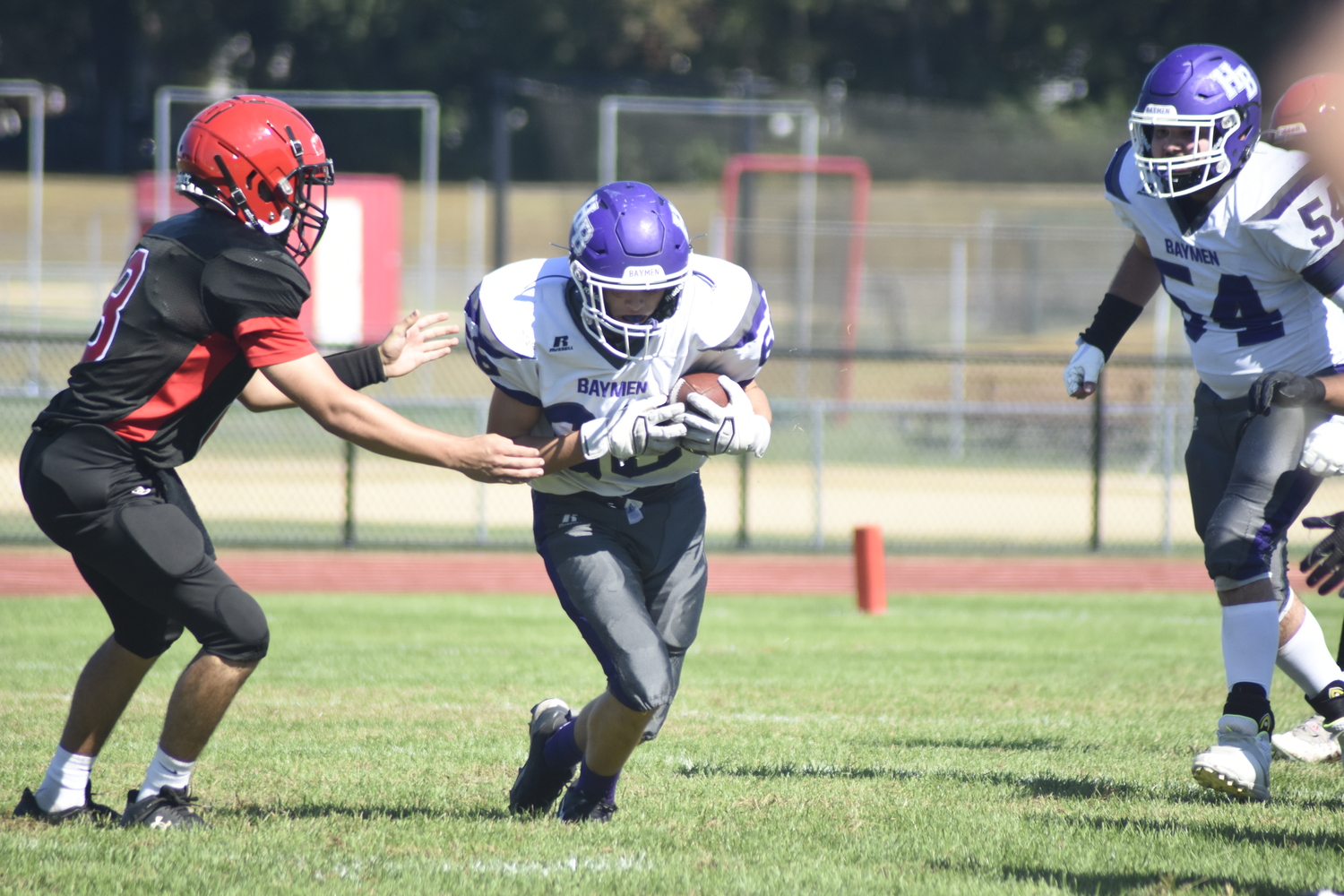 Junior Peter Scelfo scoops up a botched snap that results in a turnover for the Baymen.   DREW BUDD