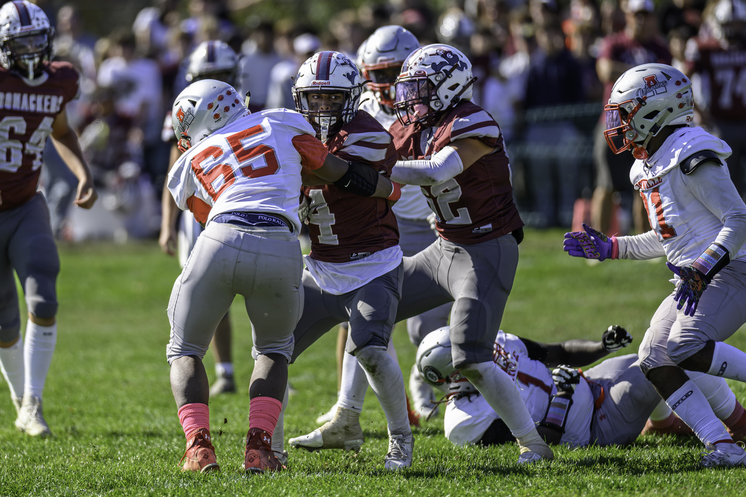 Alex Davis keeps his eyes on the end zone despite being wrapped up by an Amityville player.  MARIANNE BARNETT