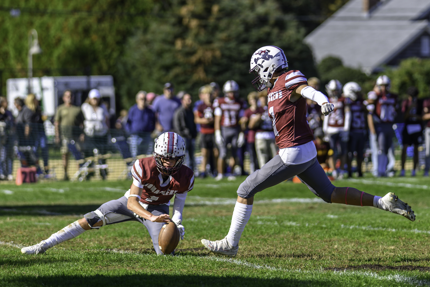 East Hampton junior Manny Morales kicks a successful extra point with junior Cole Dunchick holding.   MARIANNE BARNETT