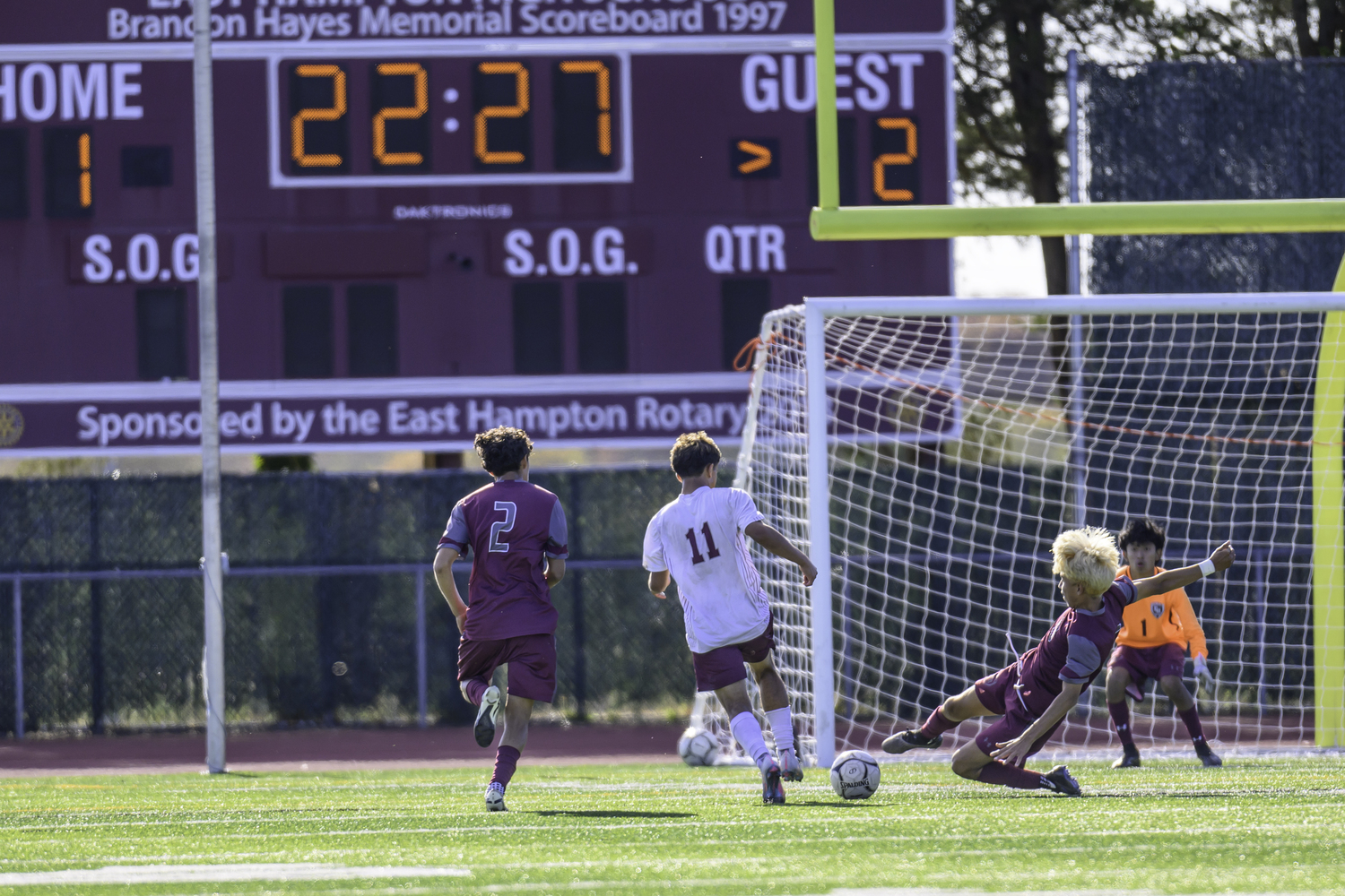 East Hampton senior Michael Chimbo successfully uses a slide tackle to block Deer Park senior Jose Escobar's shot attempt.  MARIANNE BARNETT