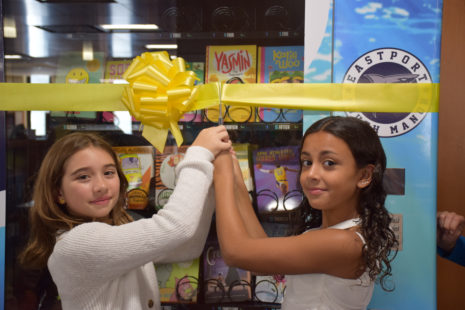 Eastport Elementary School sixth-graders Ileanna Garland and Iyla Bruno cut the ribbon for the school’s vending machine ribbon-cutting ceremony. COURTESY EASTPORT-SOUTH MANOR SCHOO DISTRICT