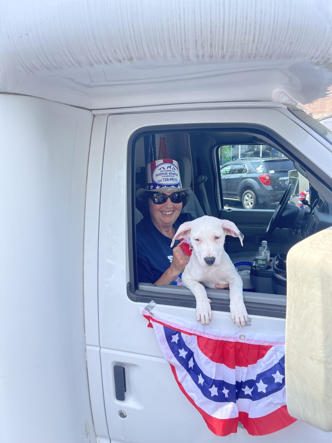 Carol Bauhs rides with a shelter dog in a Fourth of July parade. COURTESY SASF