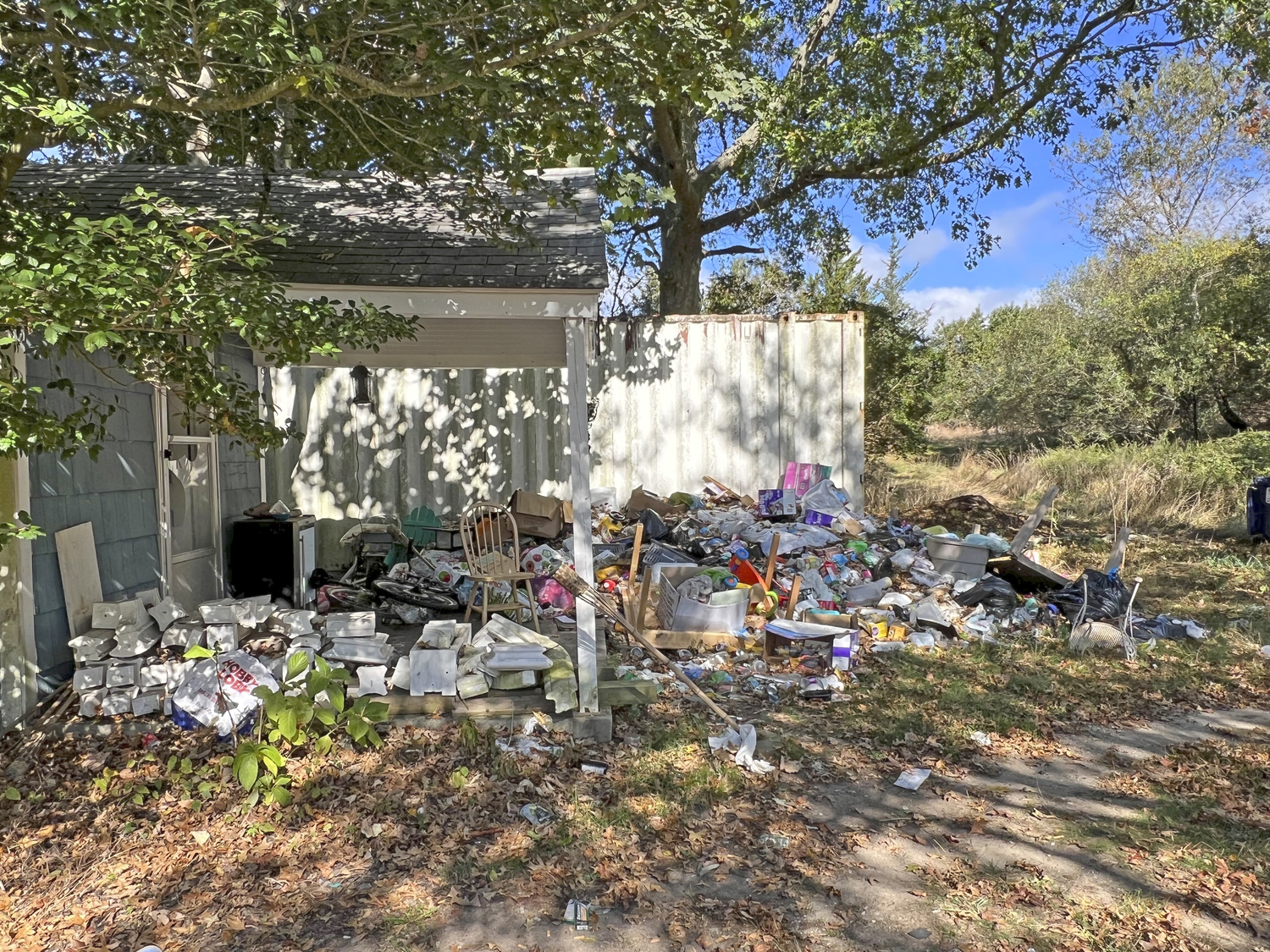 Occupants of the house created a huge trash heap off of the side of the house.  DANA SHAW