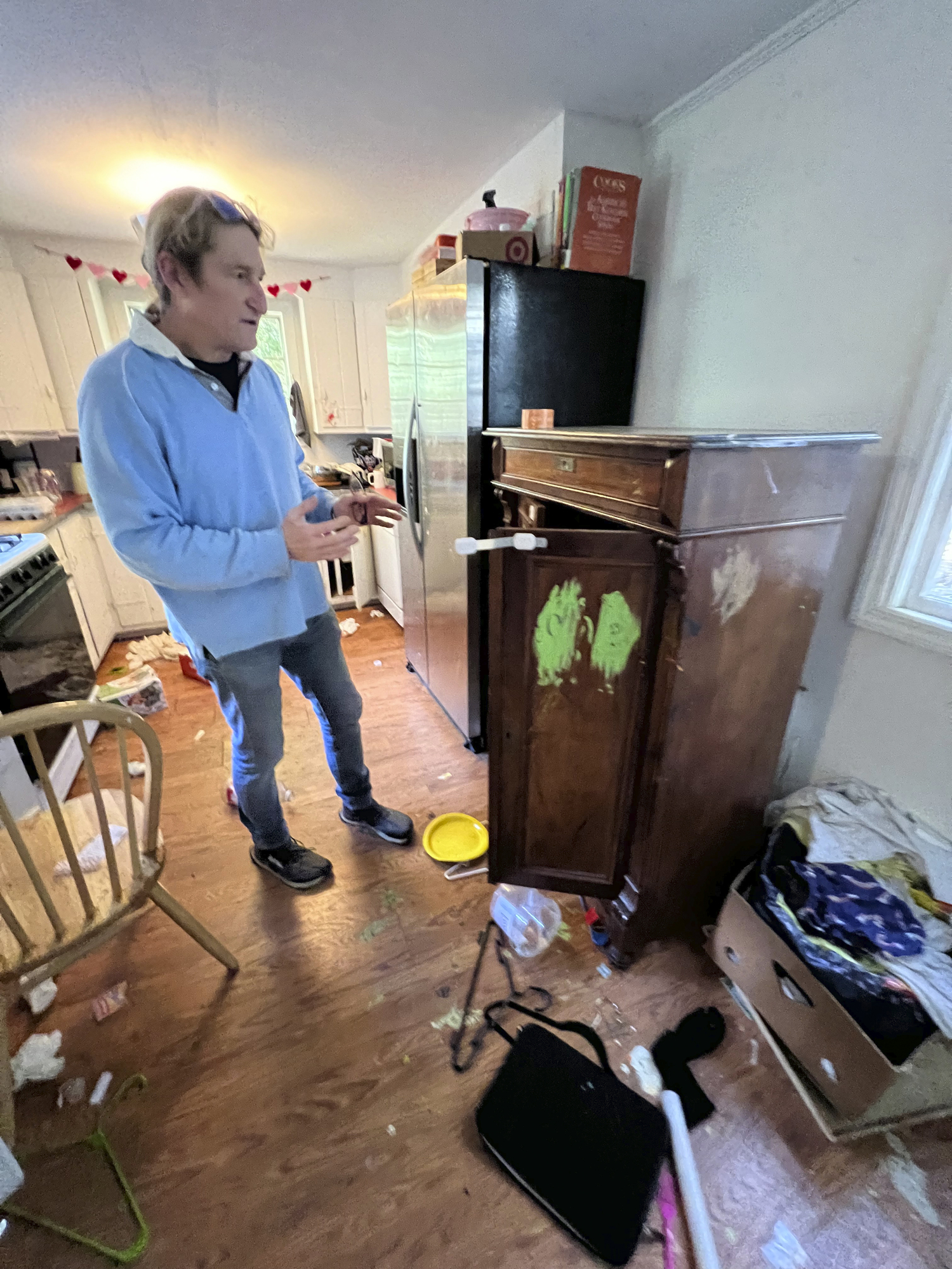 Homeowner Arnold Dormer surveys the damage to to a piece of antique furniture.  DANA SHAW