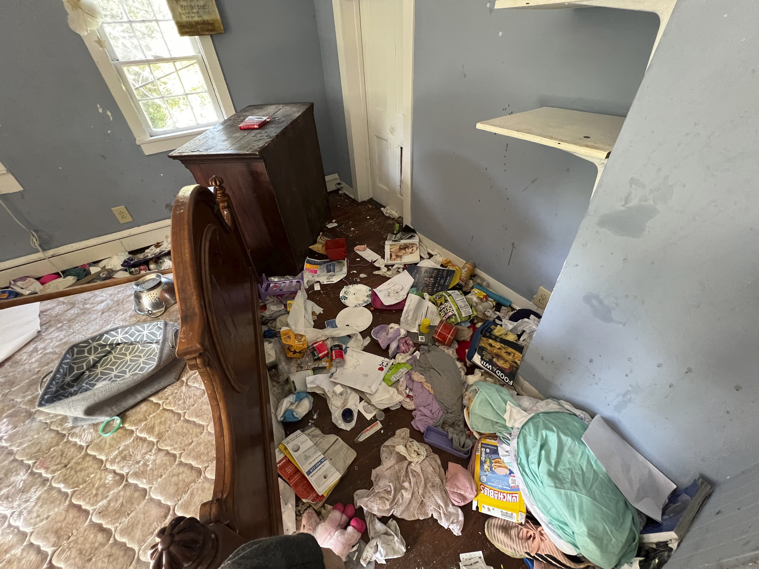 An upstairs bedroom of the home is strewn with garbage and furniture is damaged.  DANA SHAW