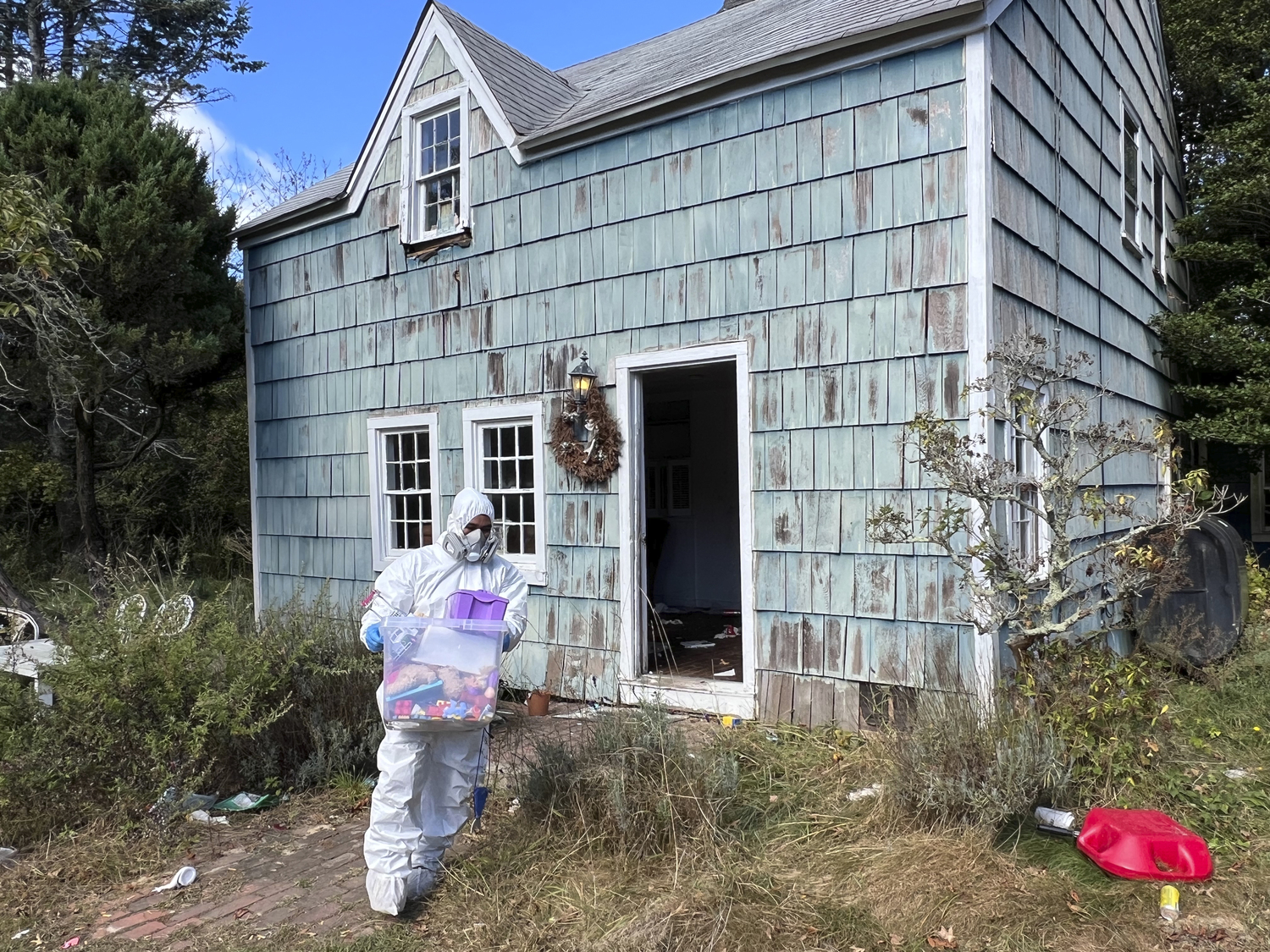 Workers in protective clothing began removing items from the home on October 10.  DANA SHAW