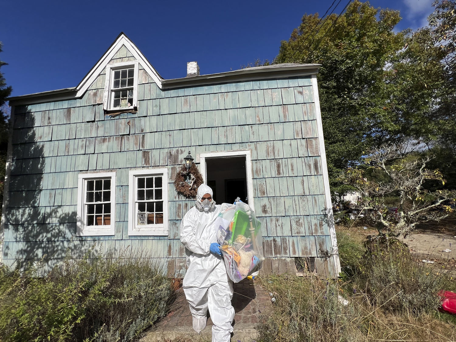 Workers in protective clothing began removing items from the home on October 10.  DANA SHAW