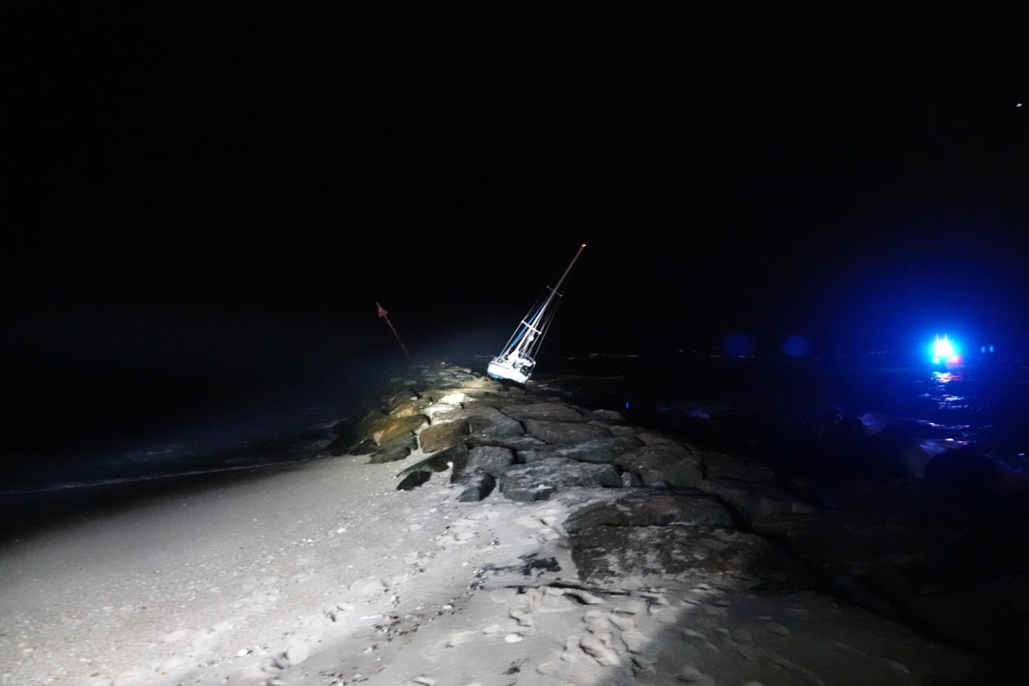 A 30 foot sailboat crashed into the east jetty of the Shinnecock Inlet on Tuesday night. The lone sailor aboard was uninjured and helped off the boat by nearby fishermen. The boat remained lodged on the rocks overnight with salvage crews expected to extract it on Wednesday morning. MICHAEL WRIGHT